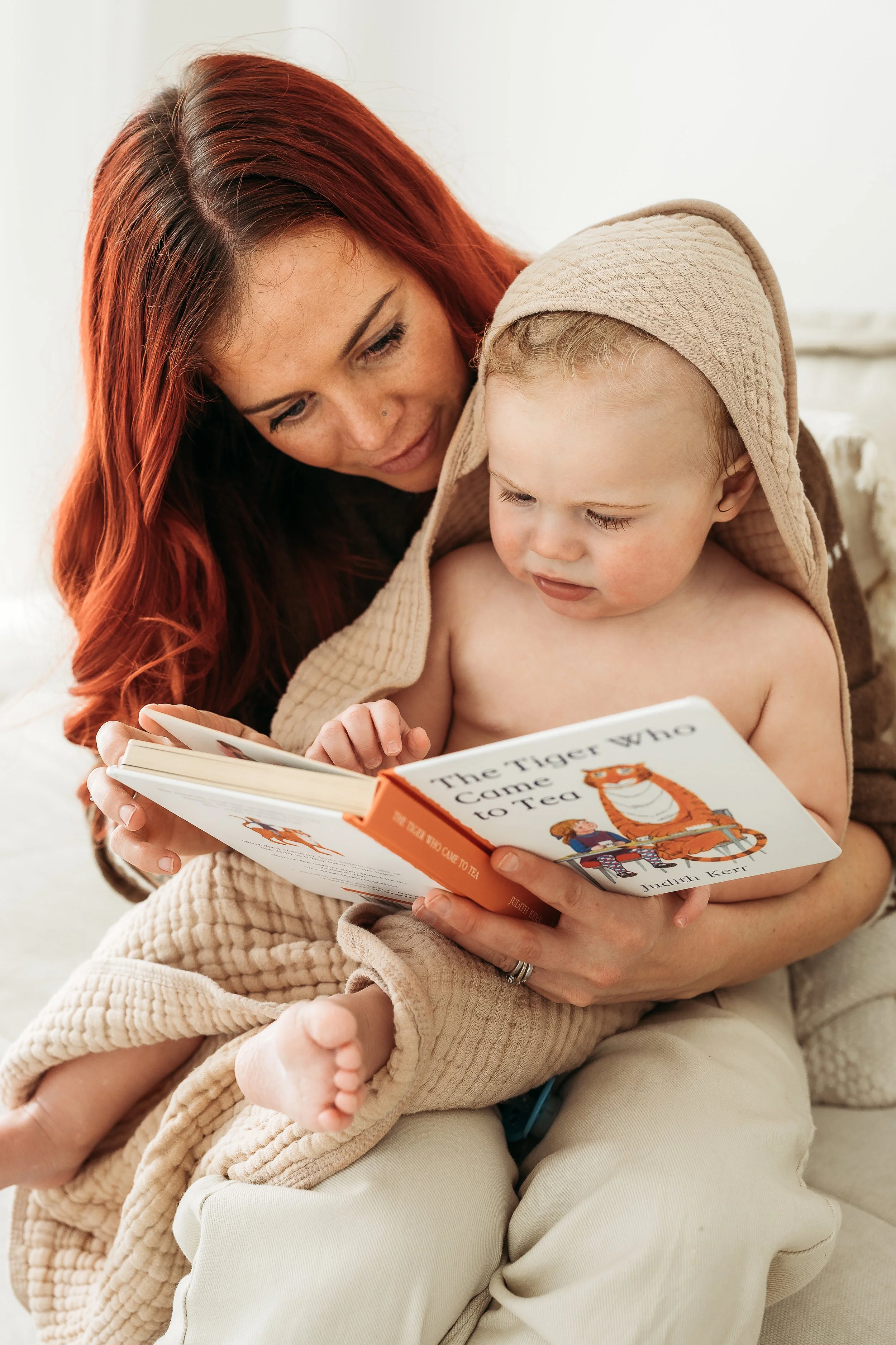 A mother and child sharing a quiet moment together, lost in a favourite story and the simple joy of being together.