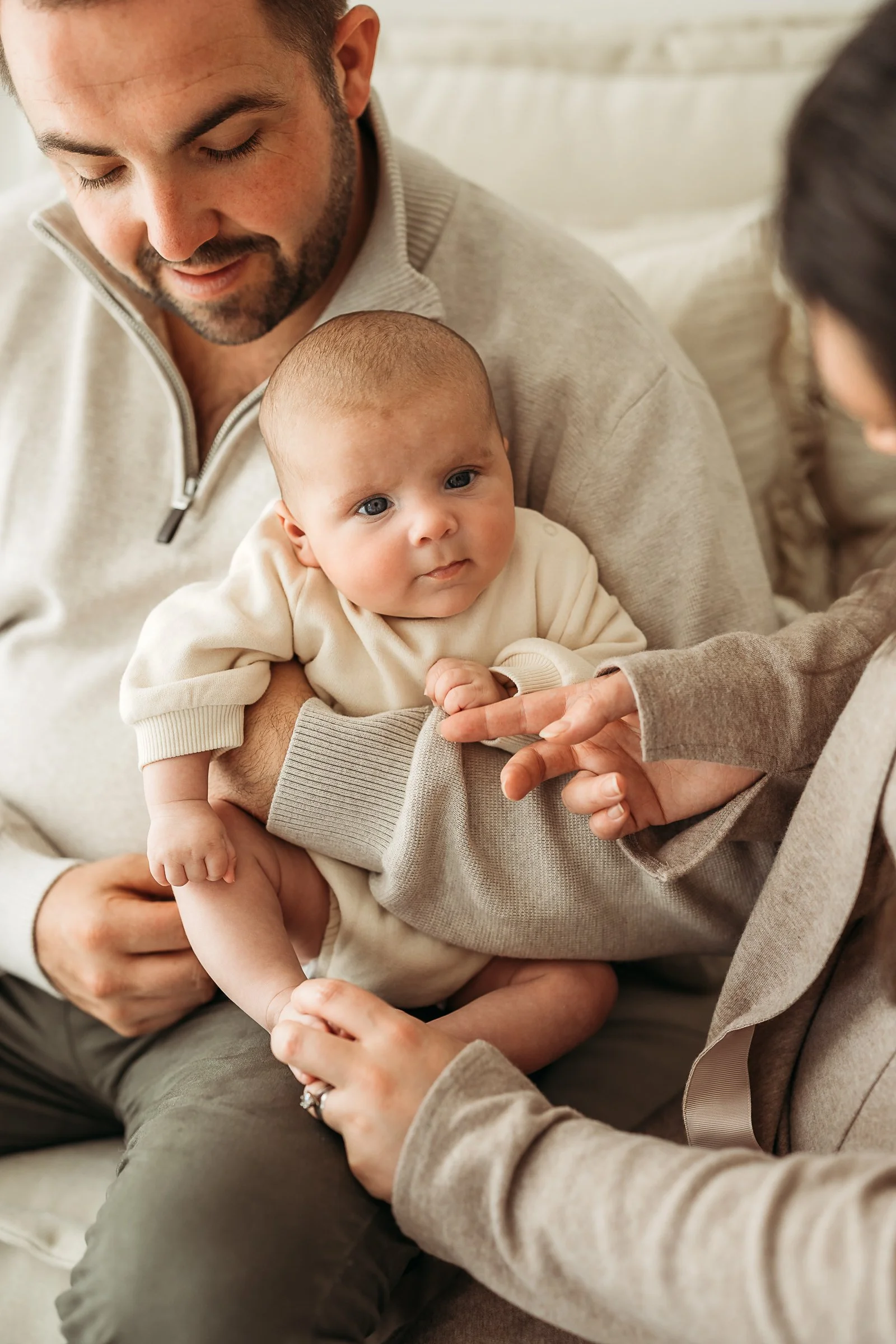 A tender family moment as parents connect with their baby, capturing the love, closeness and joy of this special season.