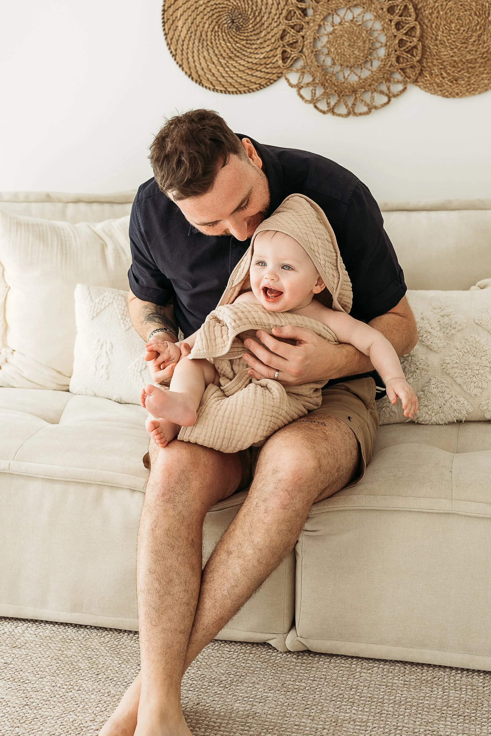 Father cuddling his baby during a relaxed first birthday photography session in a natural light studio