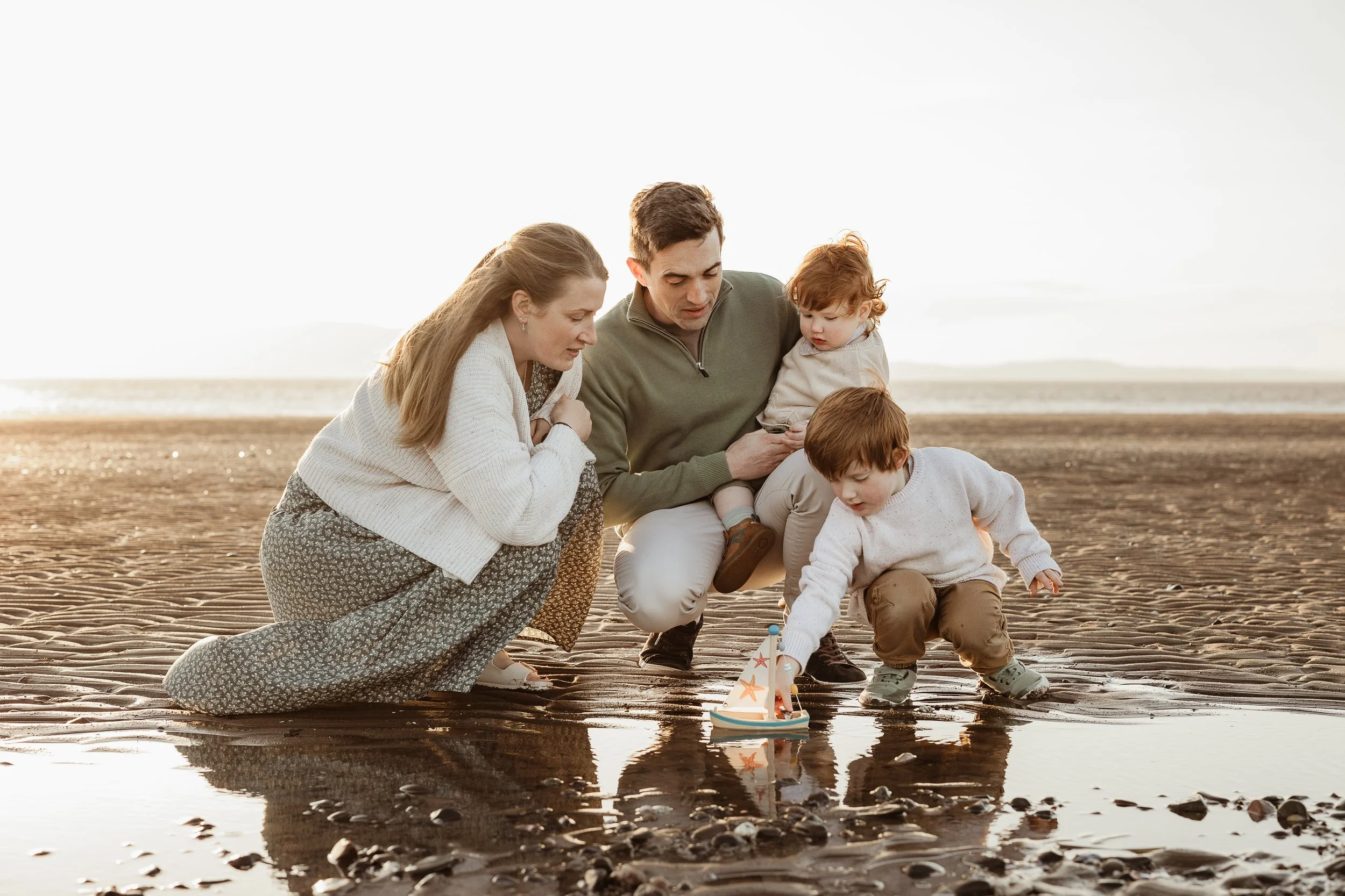 A family enjoying a simple beach adventure together, playing in the sand and creating memories by the sea.