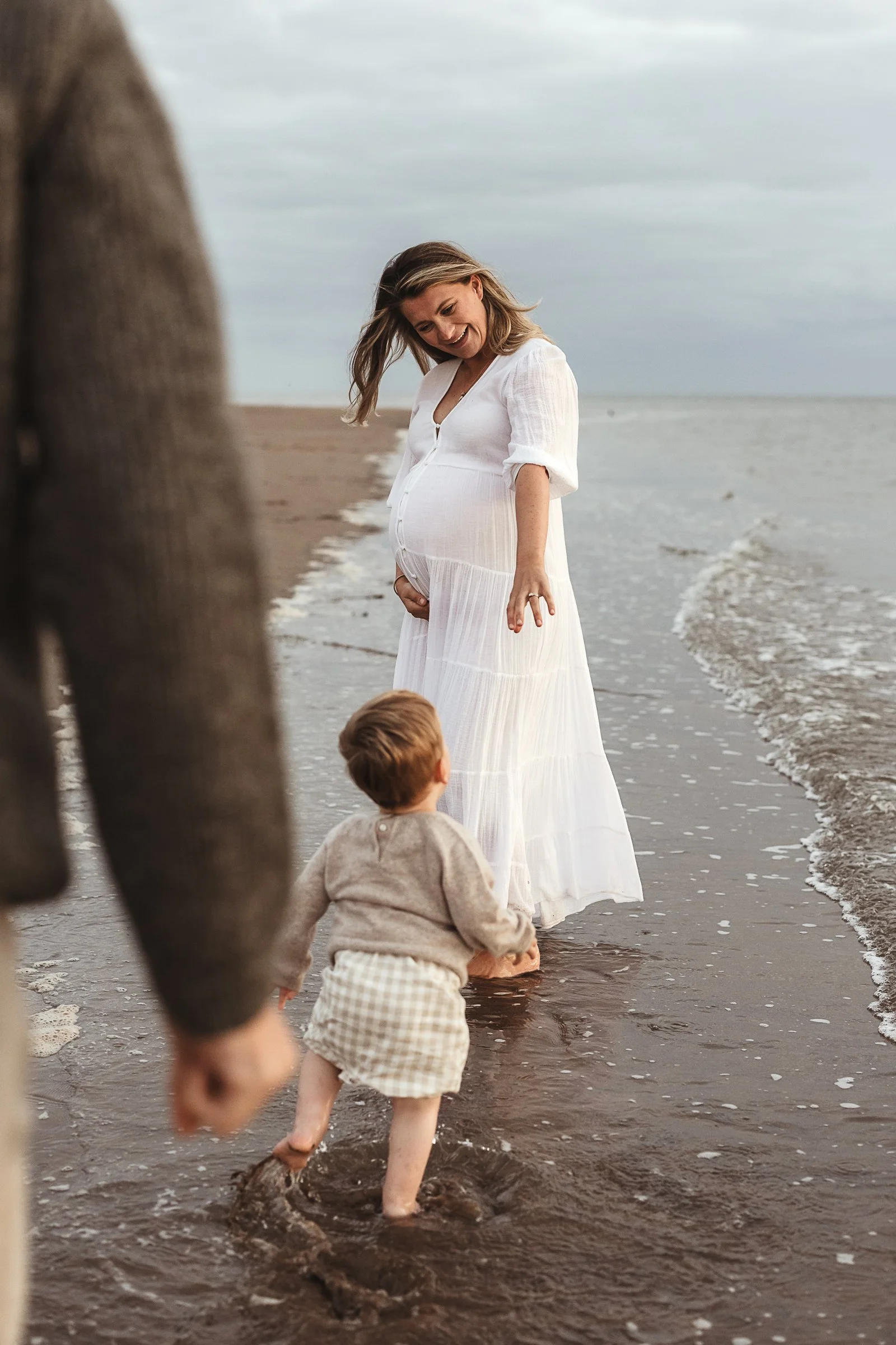 Expectant mother spending a quiet moment with her children during an outdoor maternity photography session.