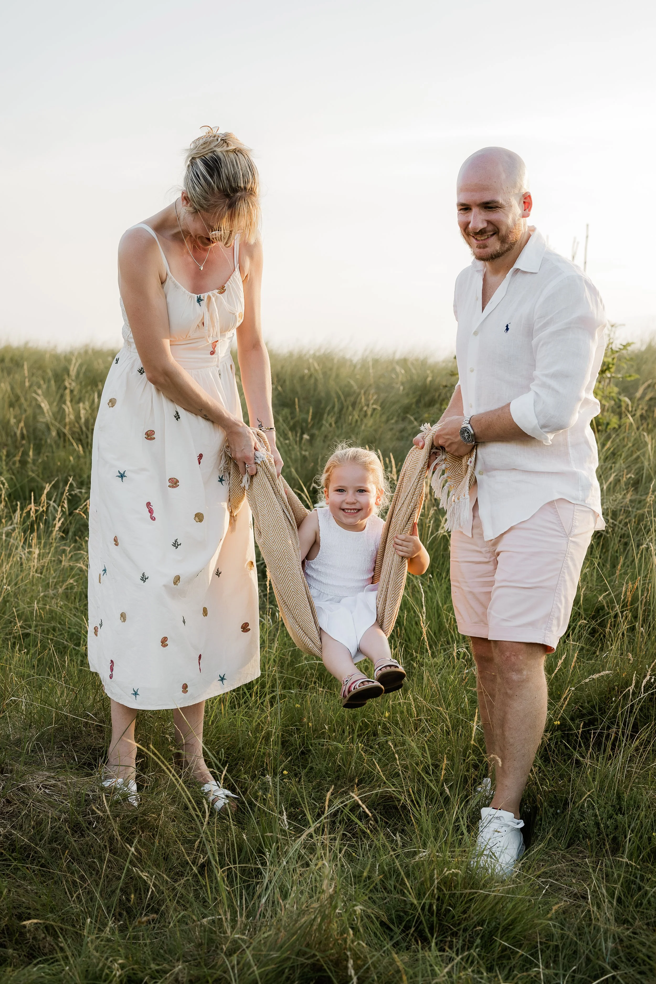 A family enjoying a play during a sunset family session.
