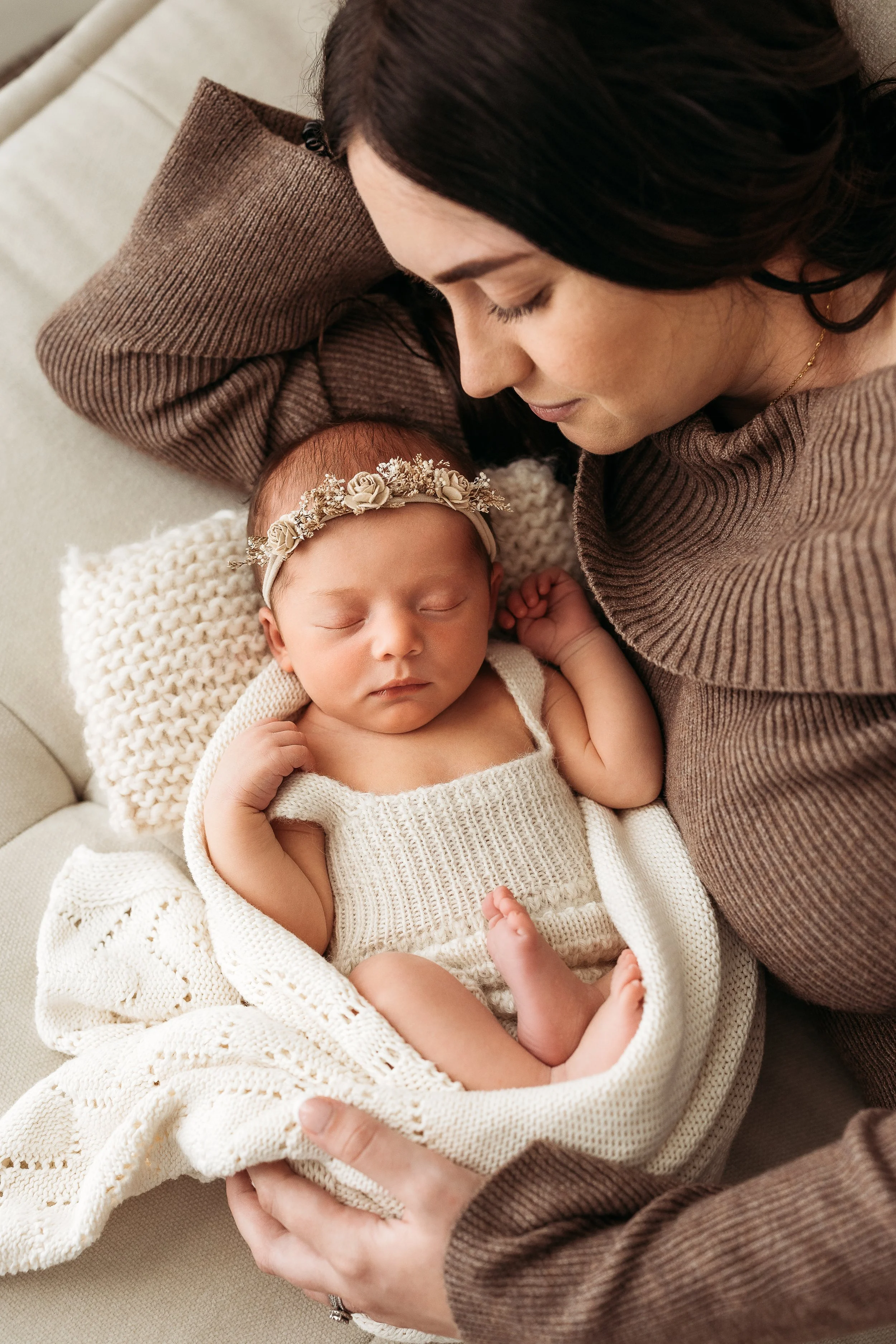 Mum cuddling her sleeping newborn baby during a natural newborn photography session.