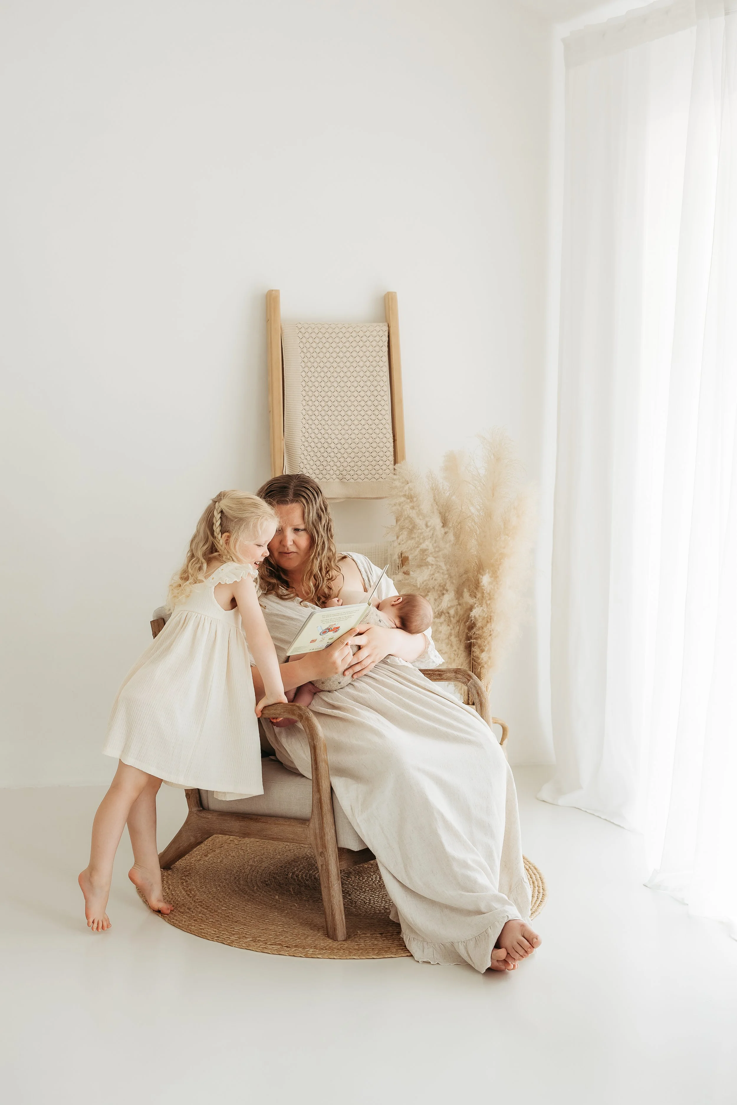 Mother reading a book with her children during a relaxed family photography session.