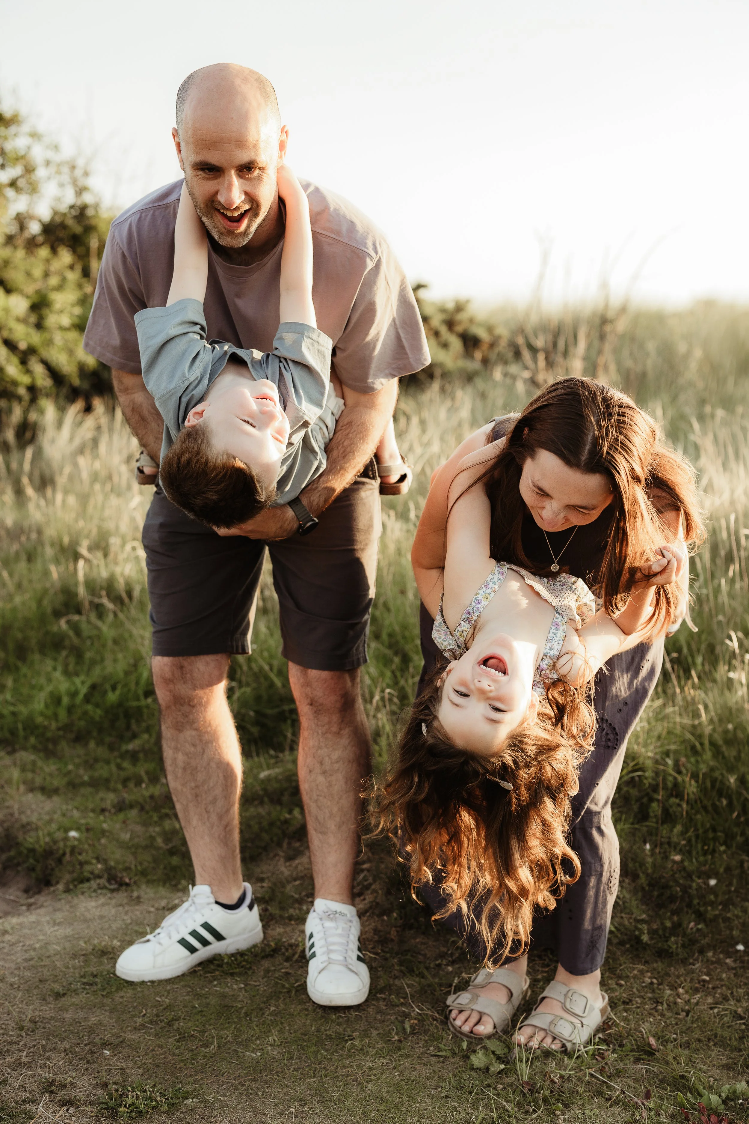 A family enjoying playful moments outdoors, capturing genuine connection, laughter and the joy of spending time together.