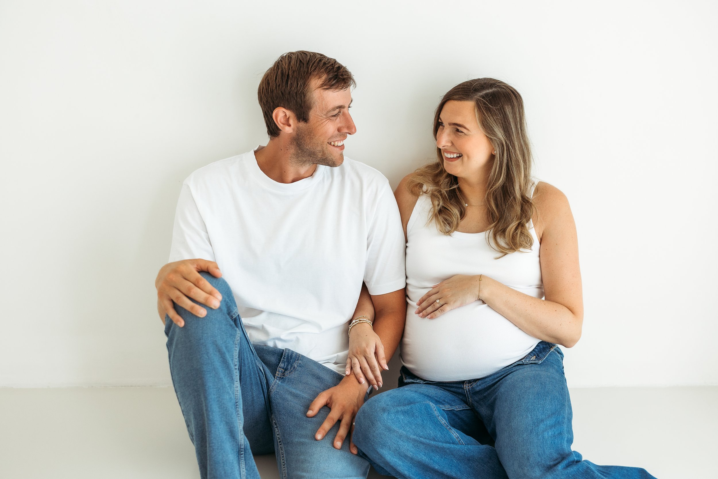 Expecting parents sharing a loving moment together during a natural maternity photography session, celebrating the excitement of their growing family.