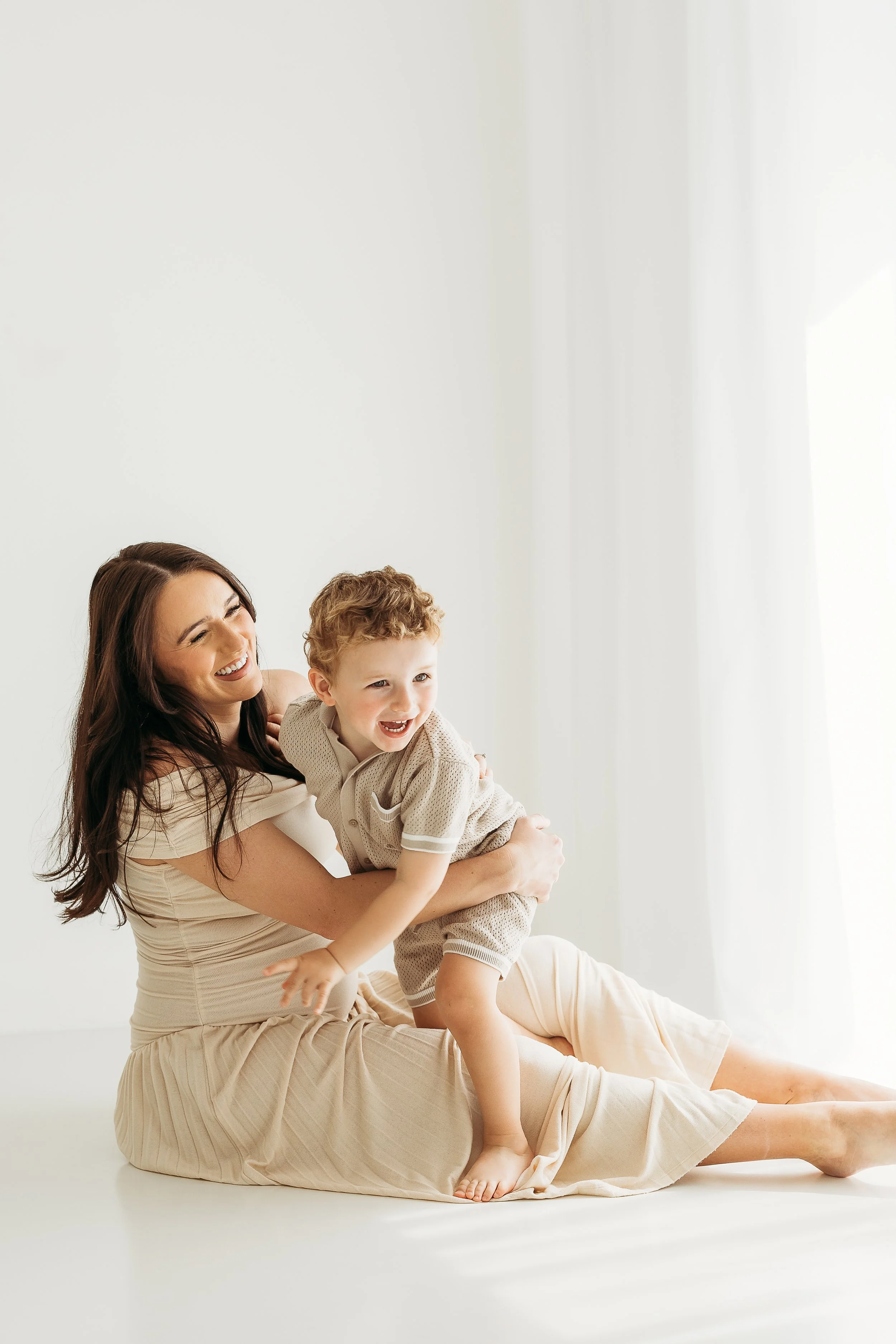 Mother and son sharing a joyful connection during a relaxed family maternity photography session.