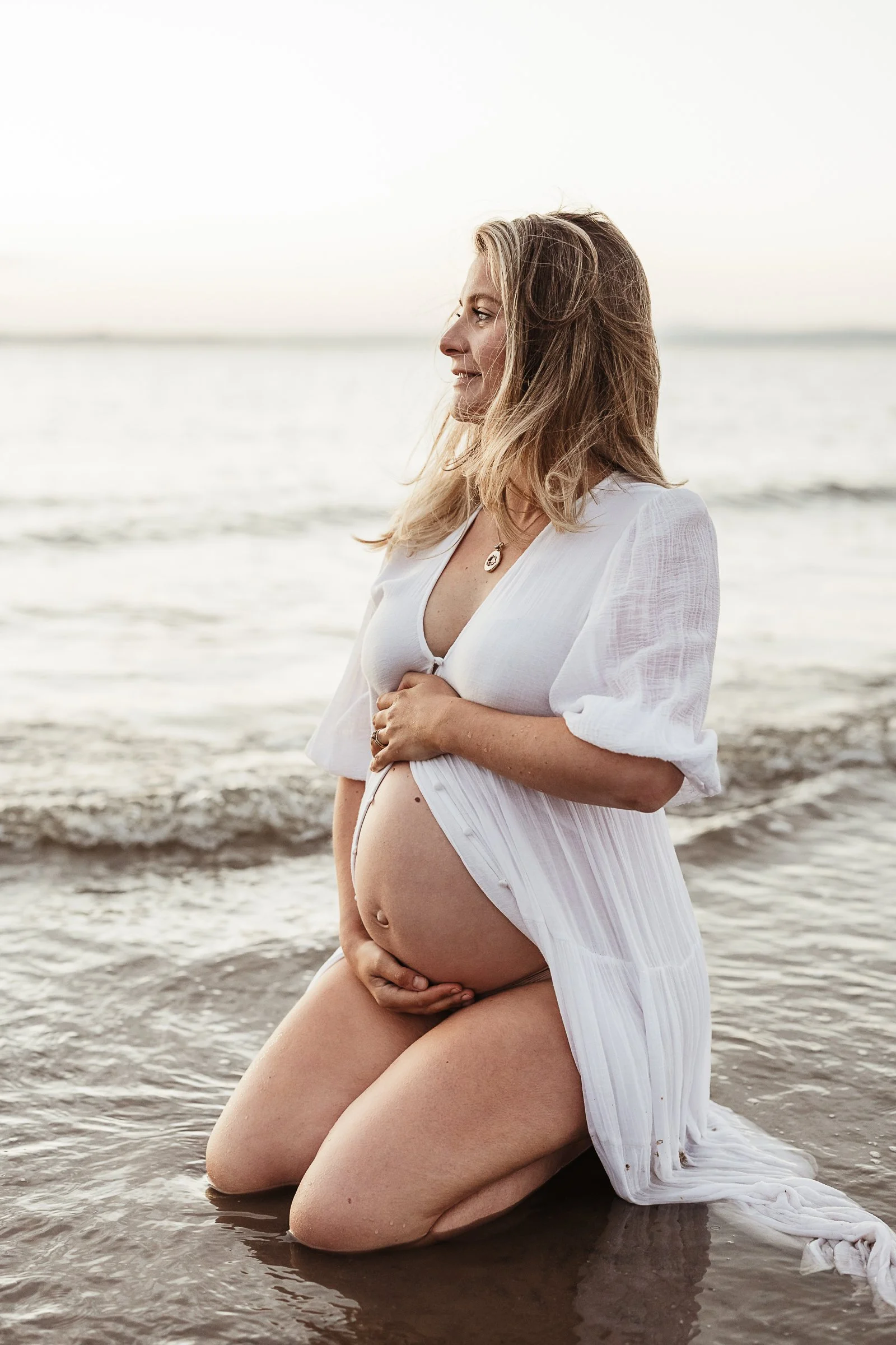 A maternity portrait by the sea, celebrating the connection between a mother and her baby before birth.