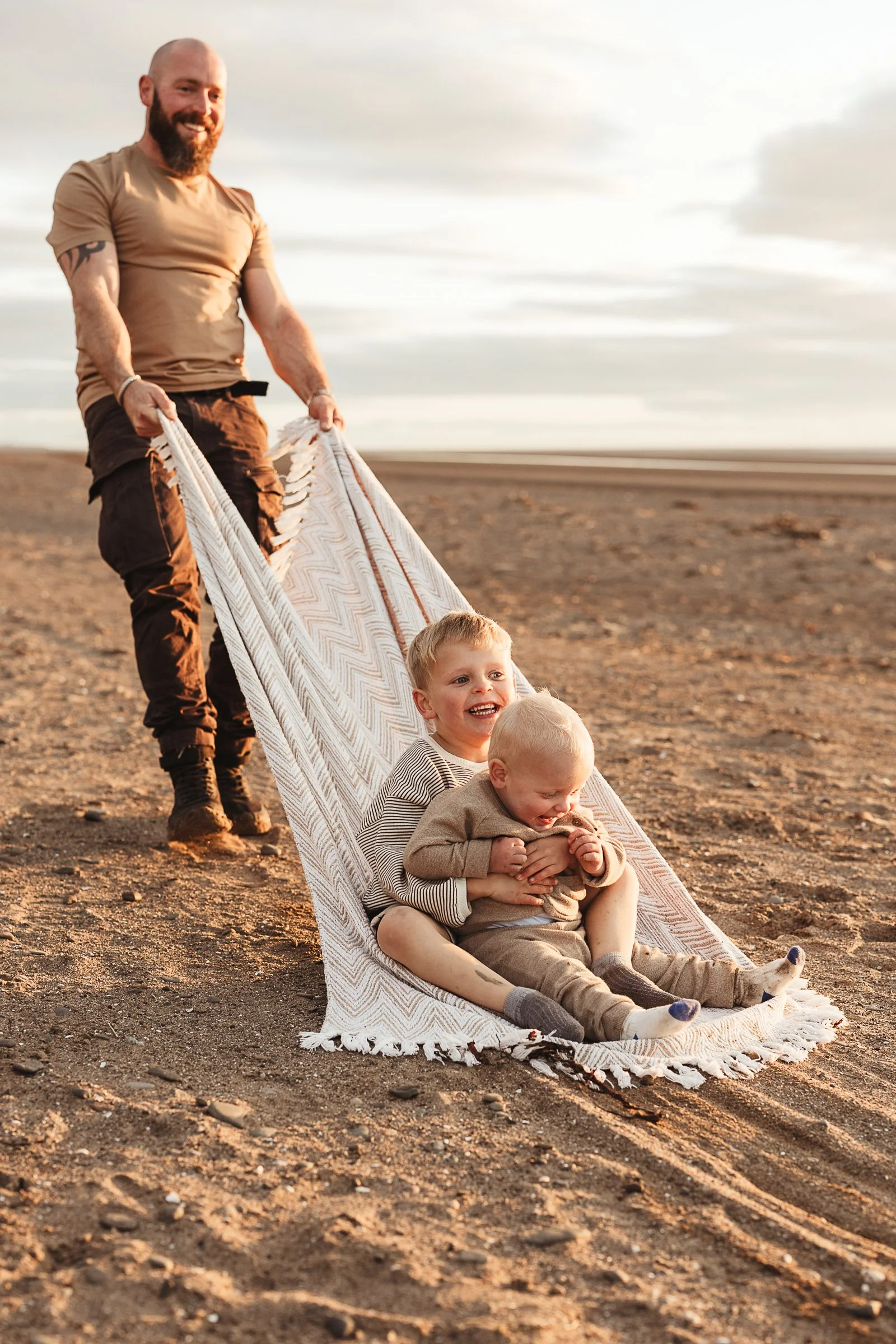 A father and children enjoying a playful beach adventure together, capturing laughter, movement and the memories made as a family.