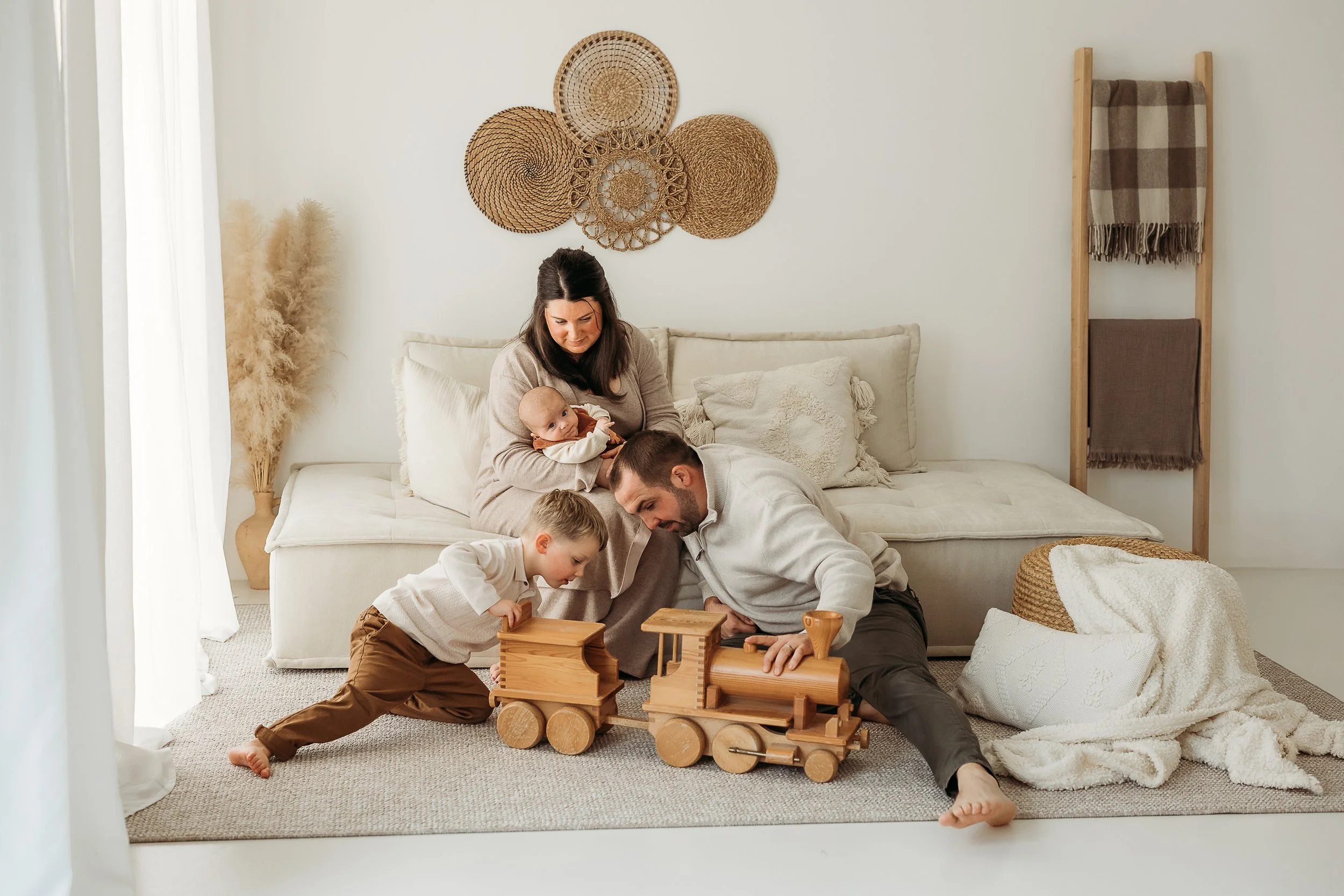 A family of five sharing everyday moments together at home, capturing the laughter, play and connection found in ordinary family life.