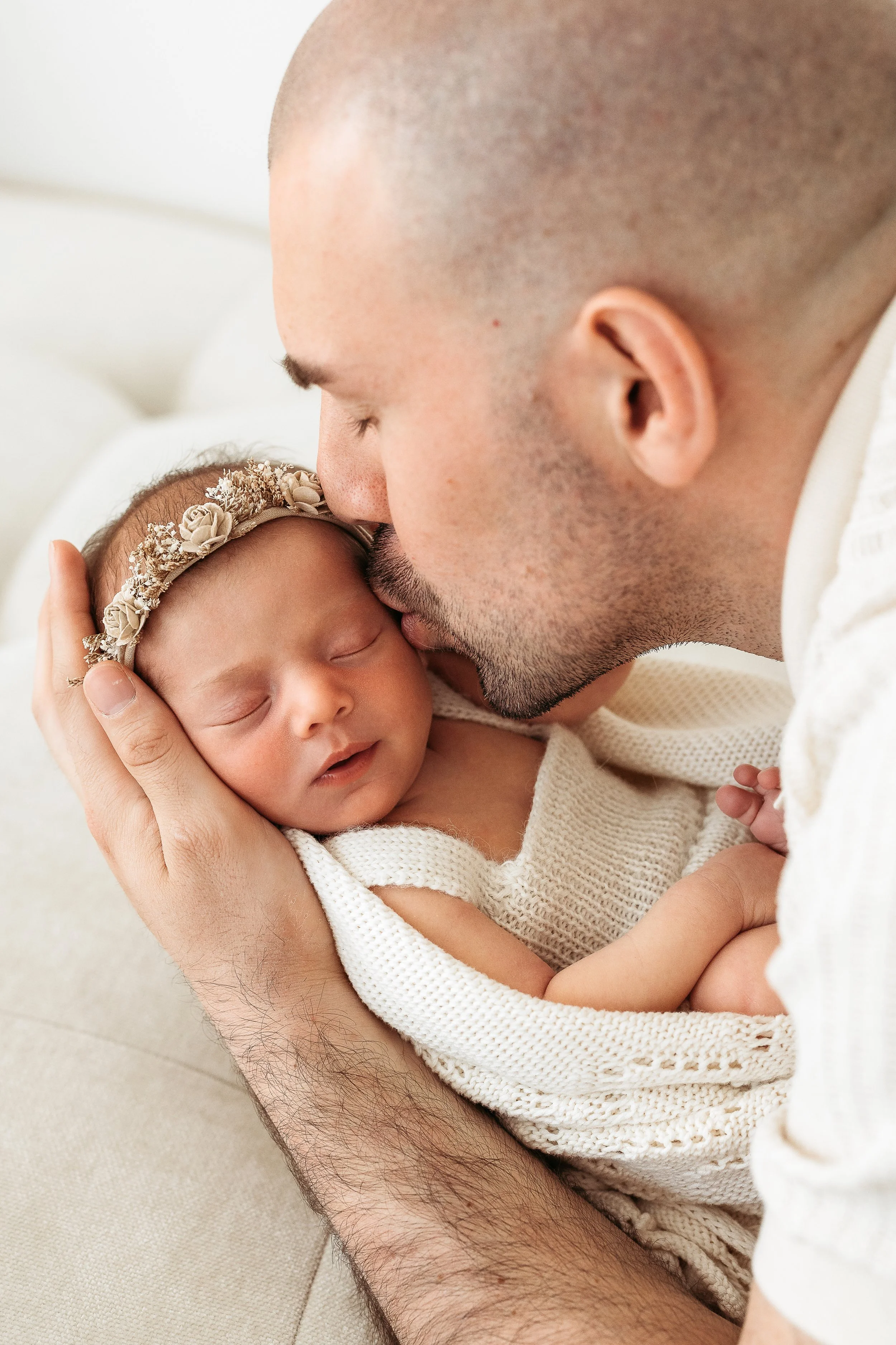 Parents lovingly holding their newborn baby during a connection-focused newborn photography session.