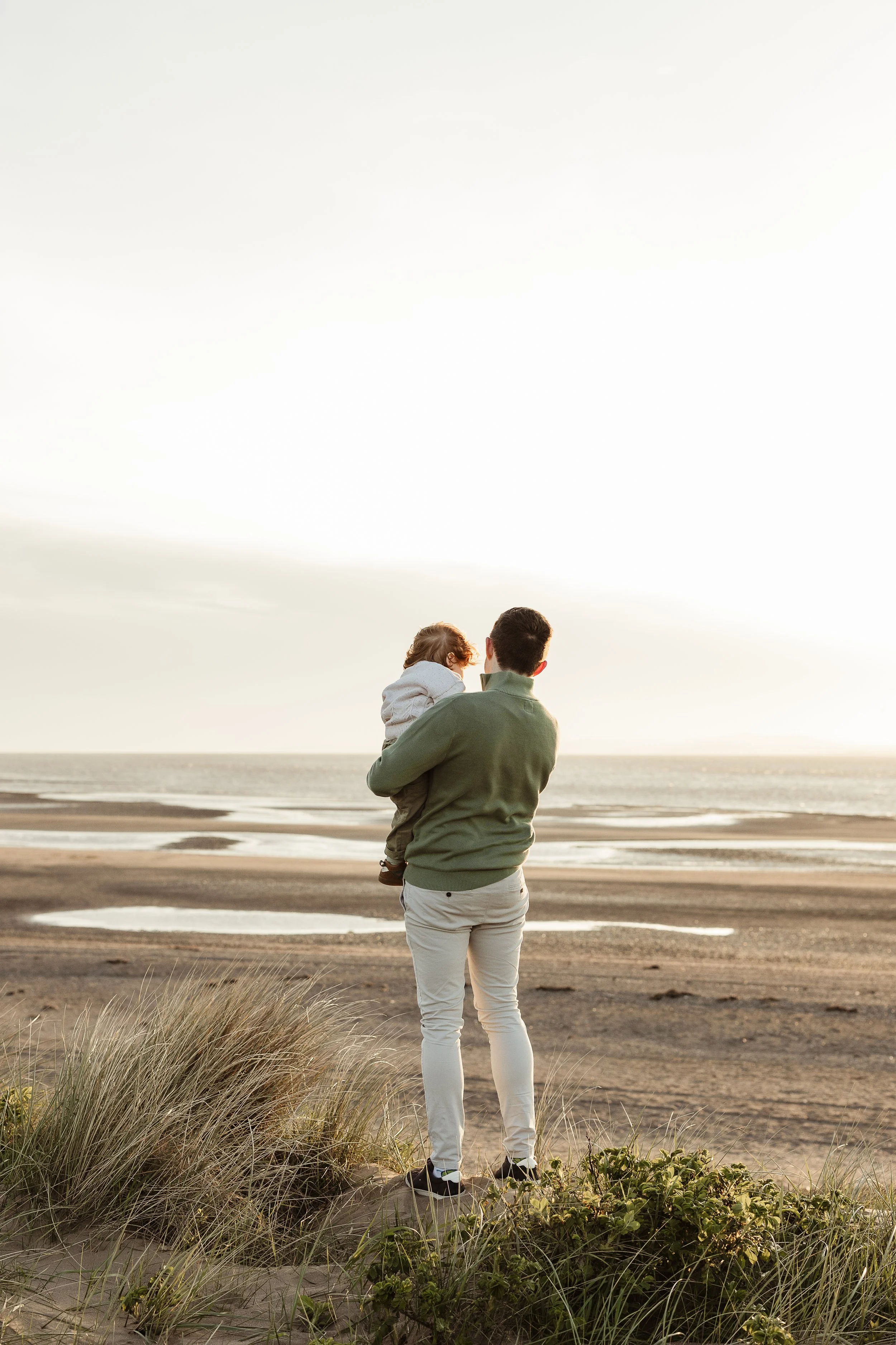 A father and daughter sharing a quiet moment together by the sea, preserving the love and connection between them.