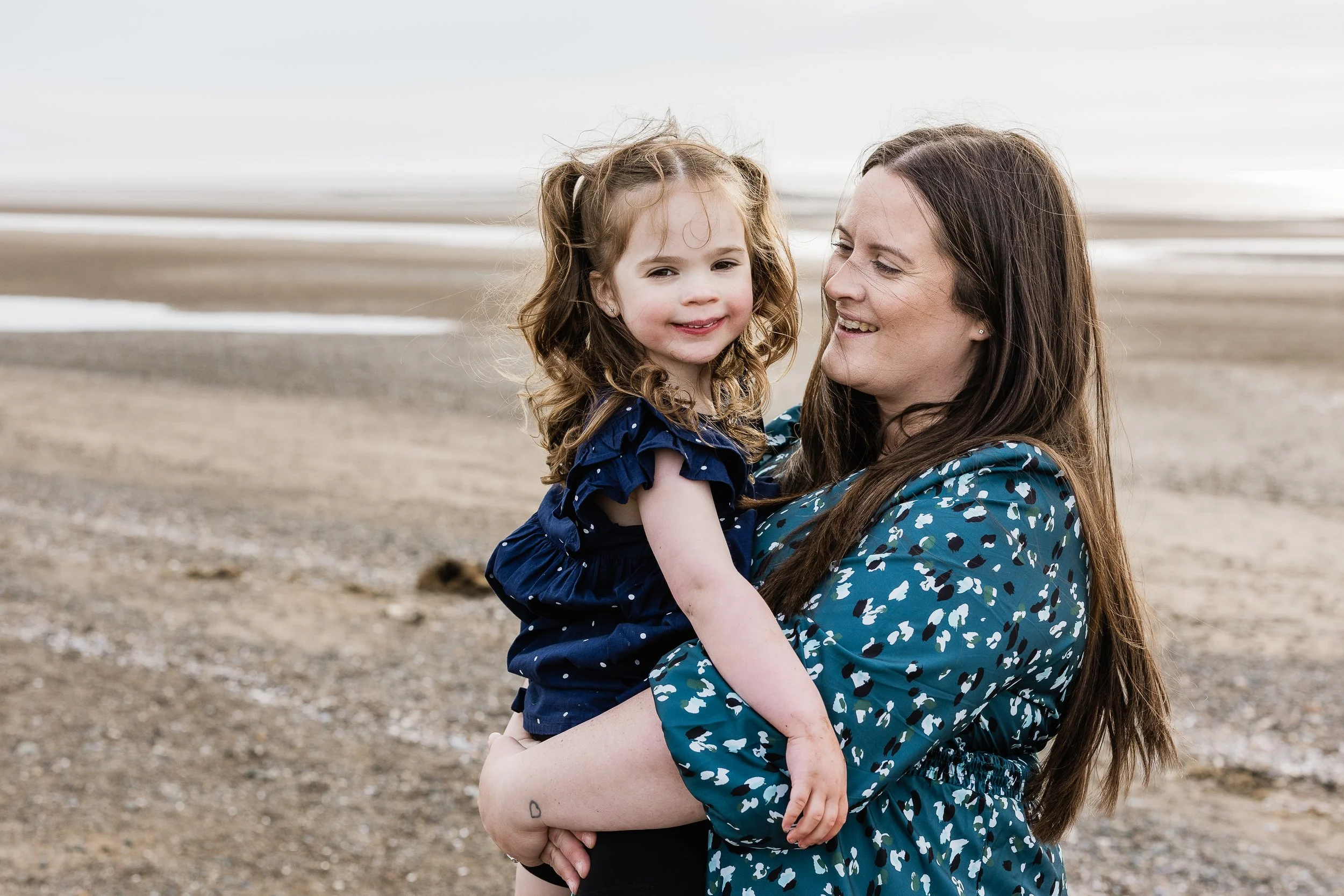 A mother and daughter sharing a beautiful beach moment together, preserving their connection, affection and the memories of childhood.