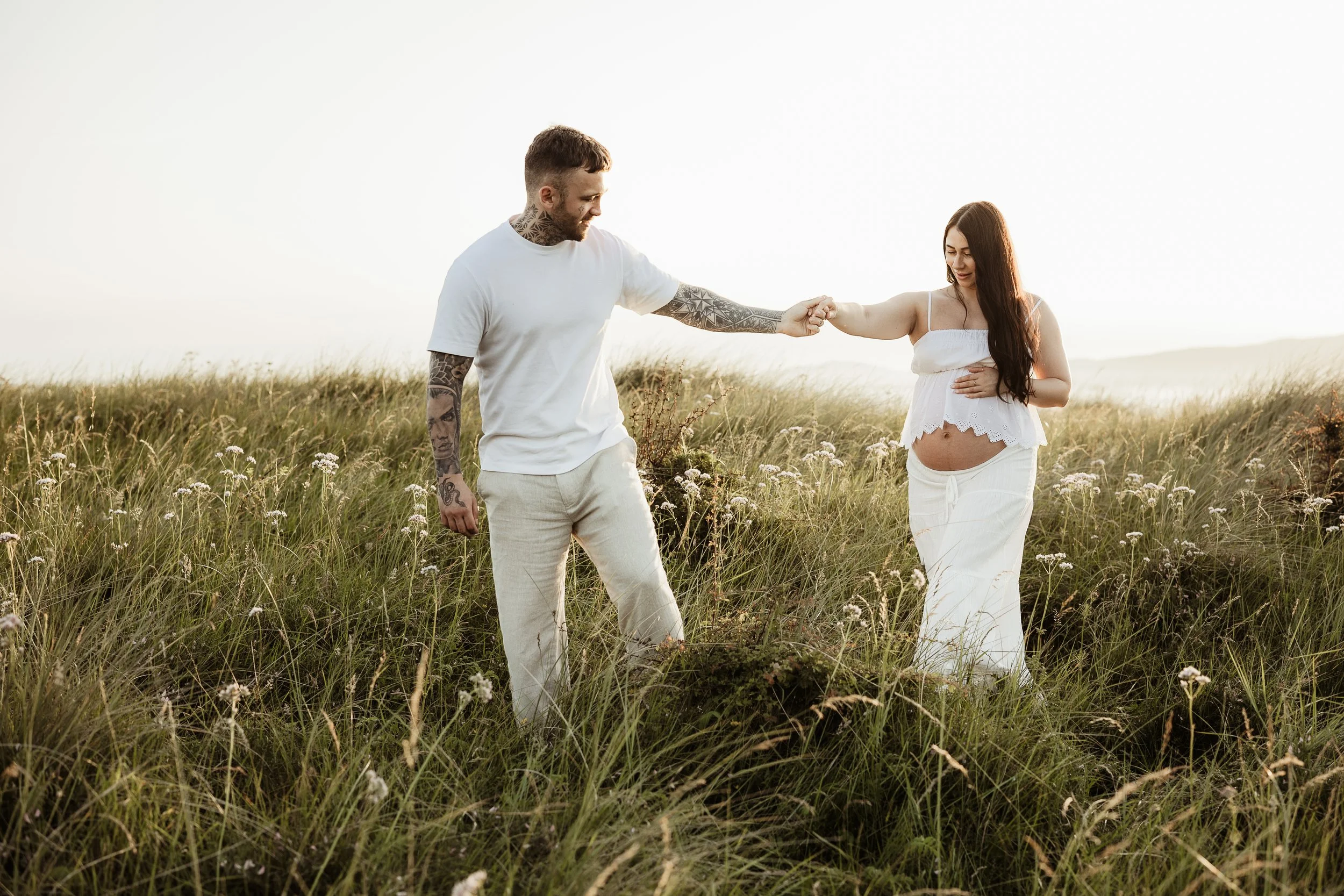 Expecting parents sharing a quiet moment together surrounded by nature during an outdoor maternity photography session.