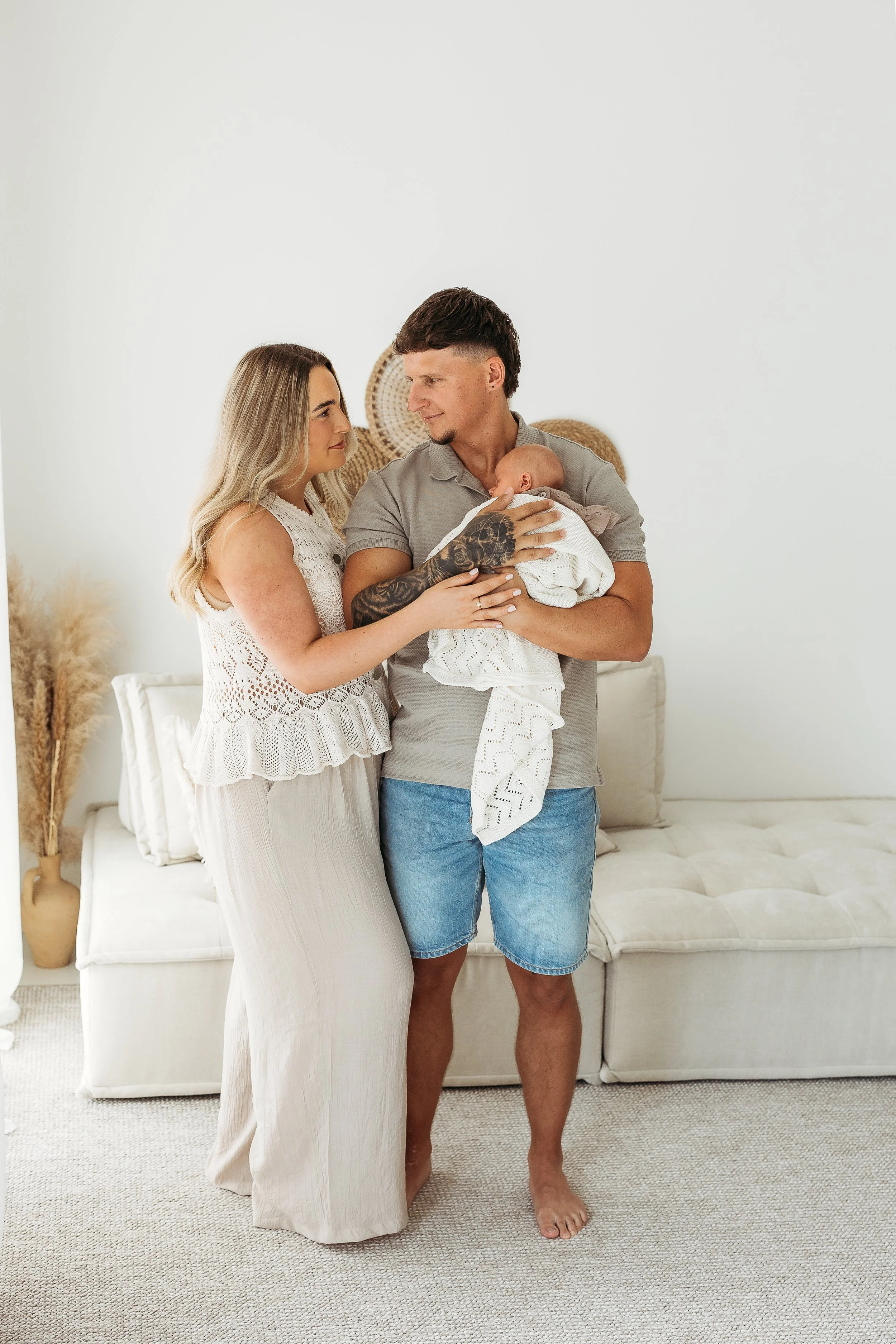 Parents holding their newborn baby together during a natural studio newborn session.