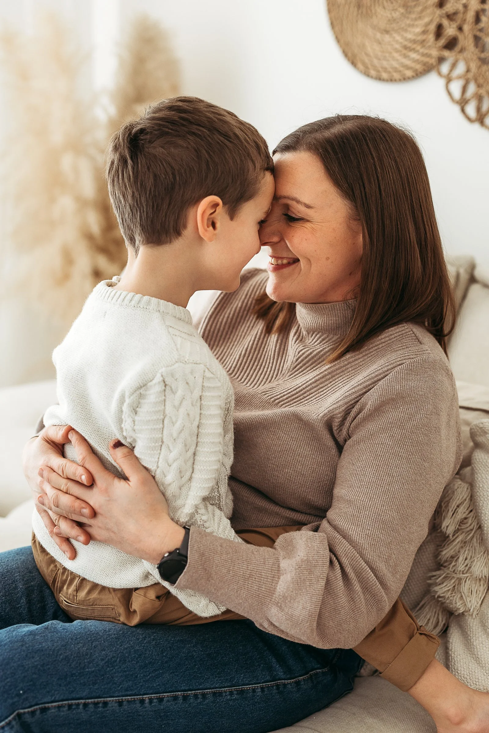 A mother and son sharing a gentle moment of connection, forehead to forehead, capturing the closeness and love between them.