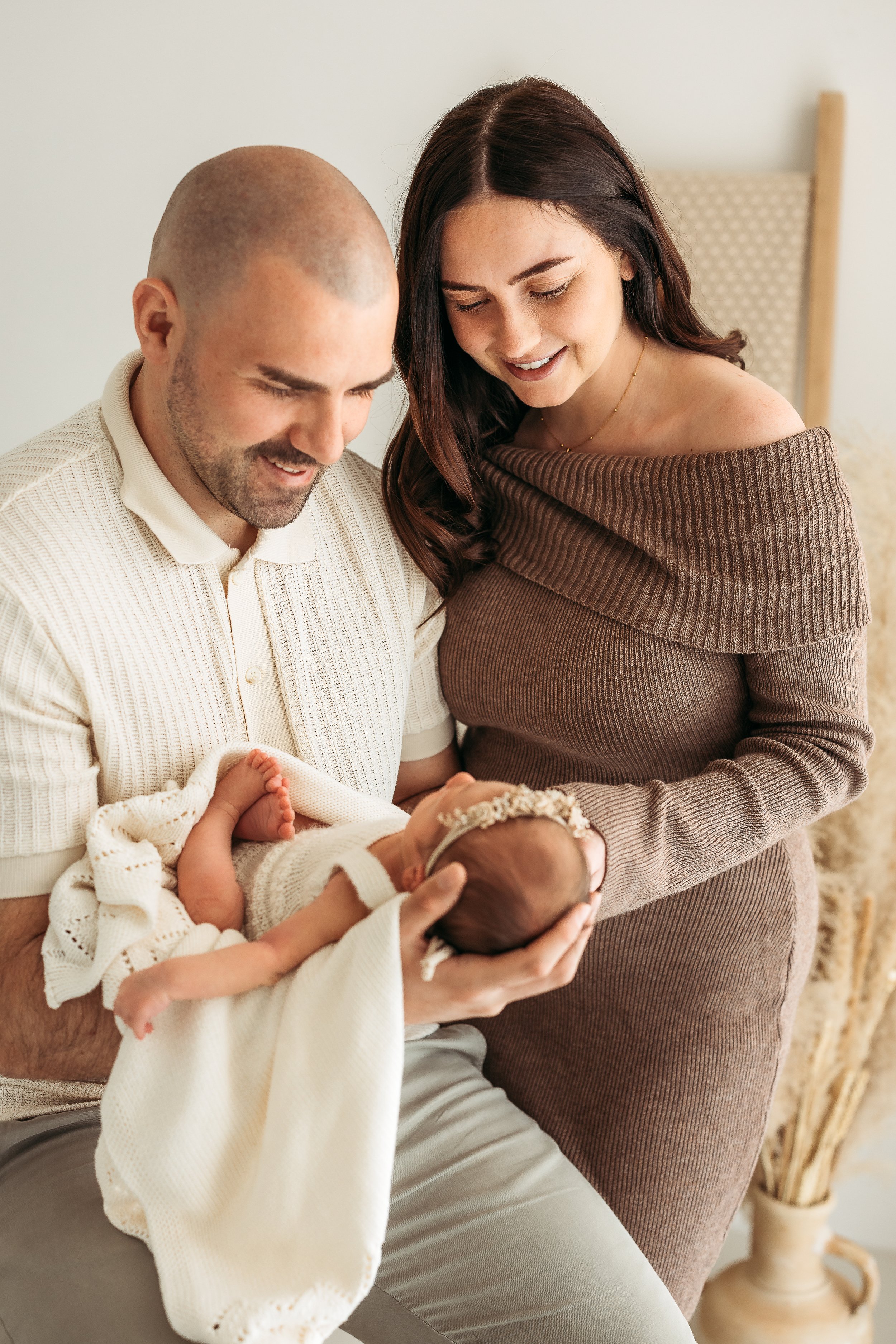Parents sharing a quiet moment together with their newborn baby during a natural family newborn photography session.