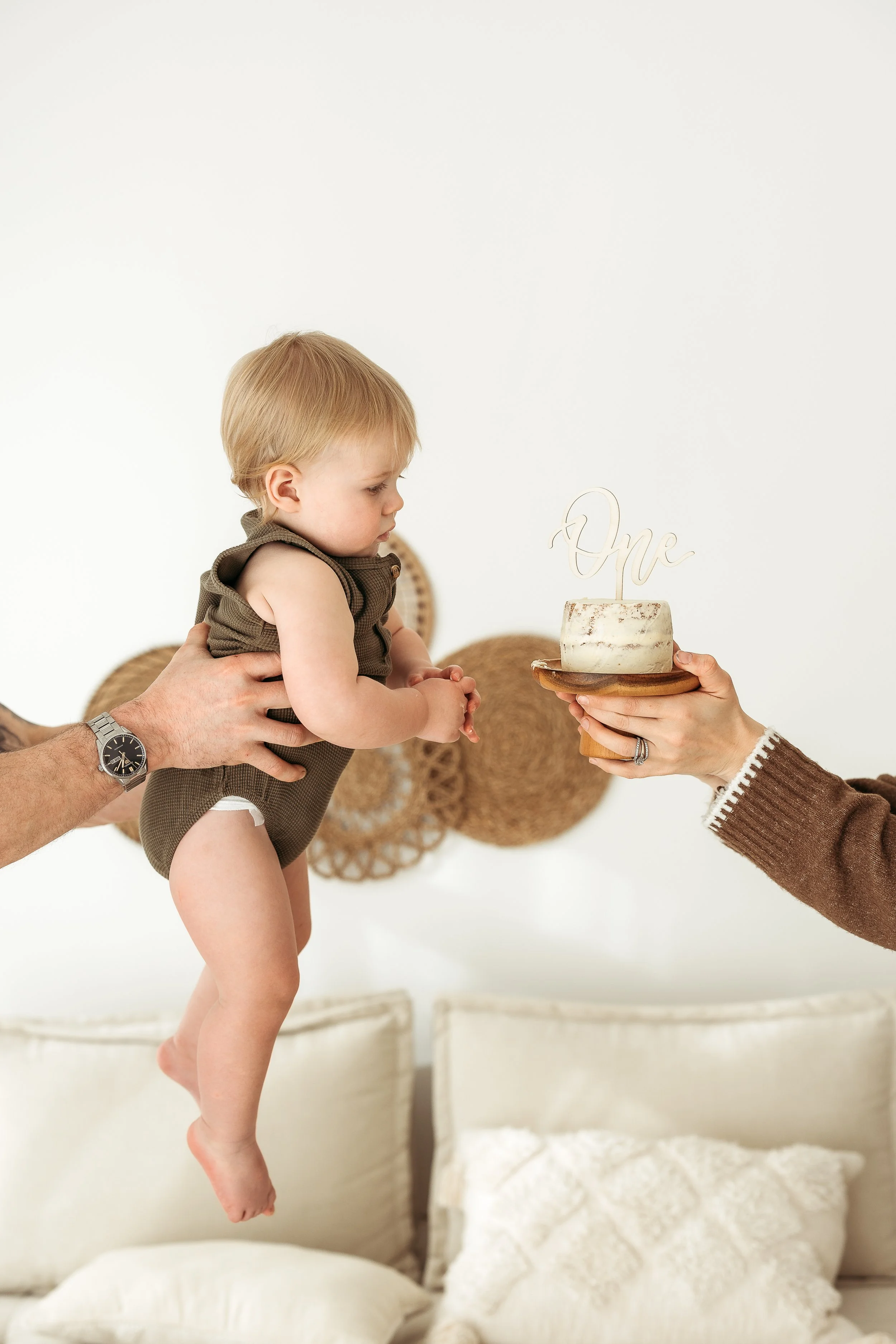 A little one discovering their first birthday cake, capturing curiosity, excitement and the joy of this special milestone.