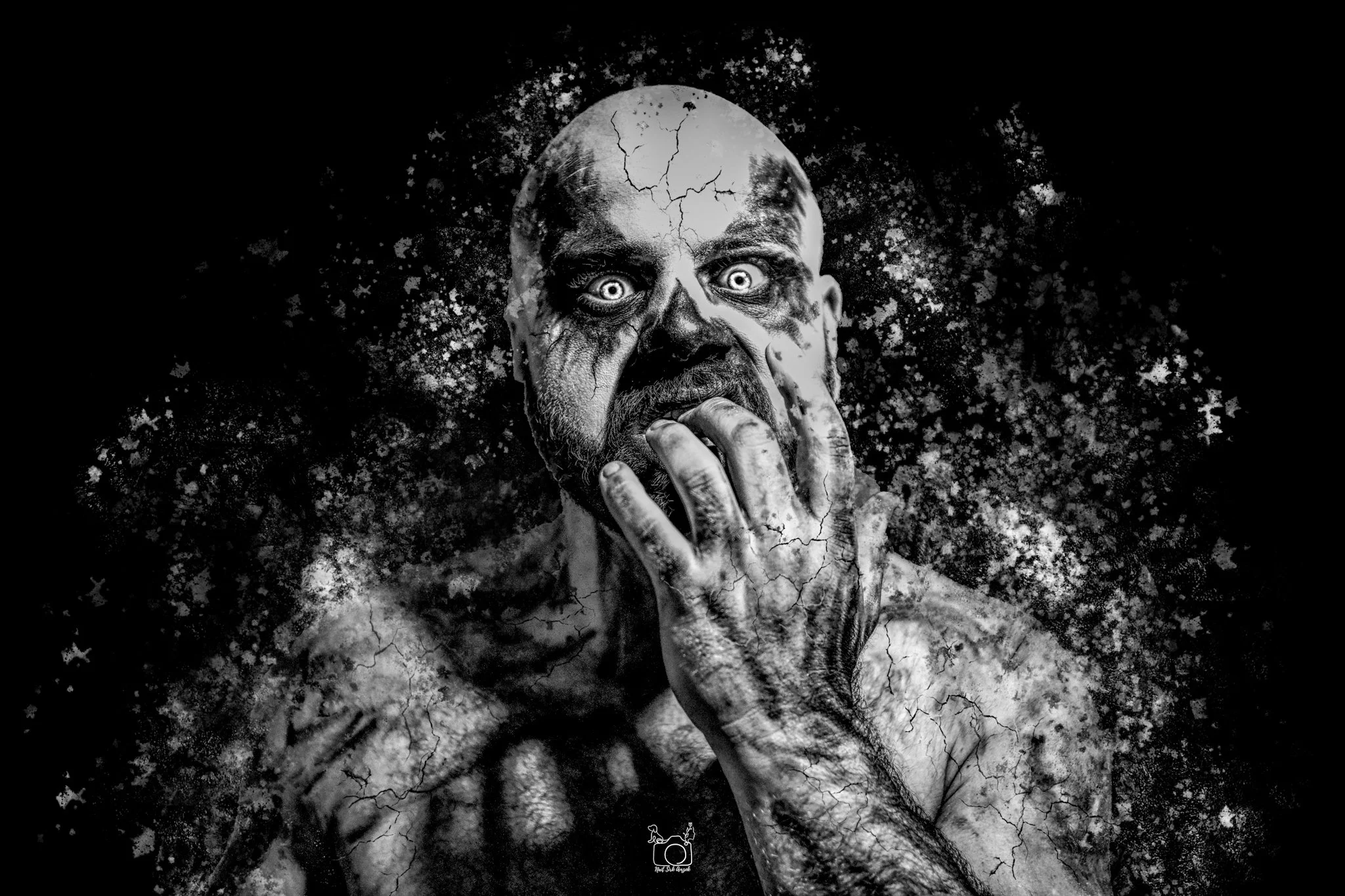 A black and white digital artwork depicting a frightening face with cracked skin, intense eyes, and a skeletal hand near the mouth, surrounded by abstract dark textures.