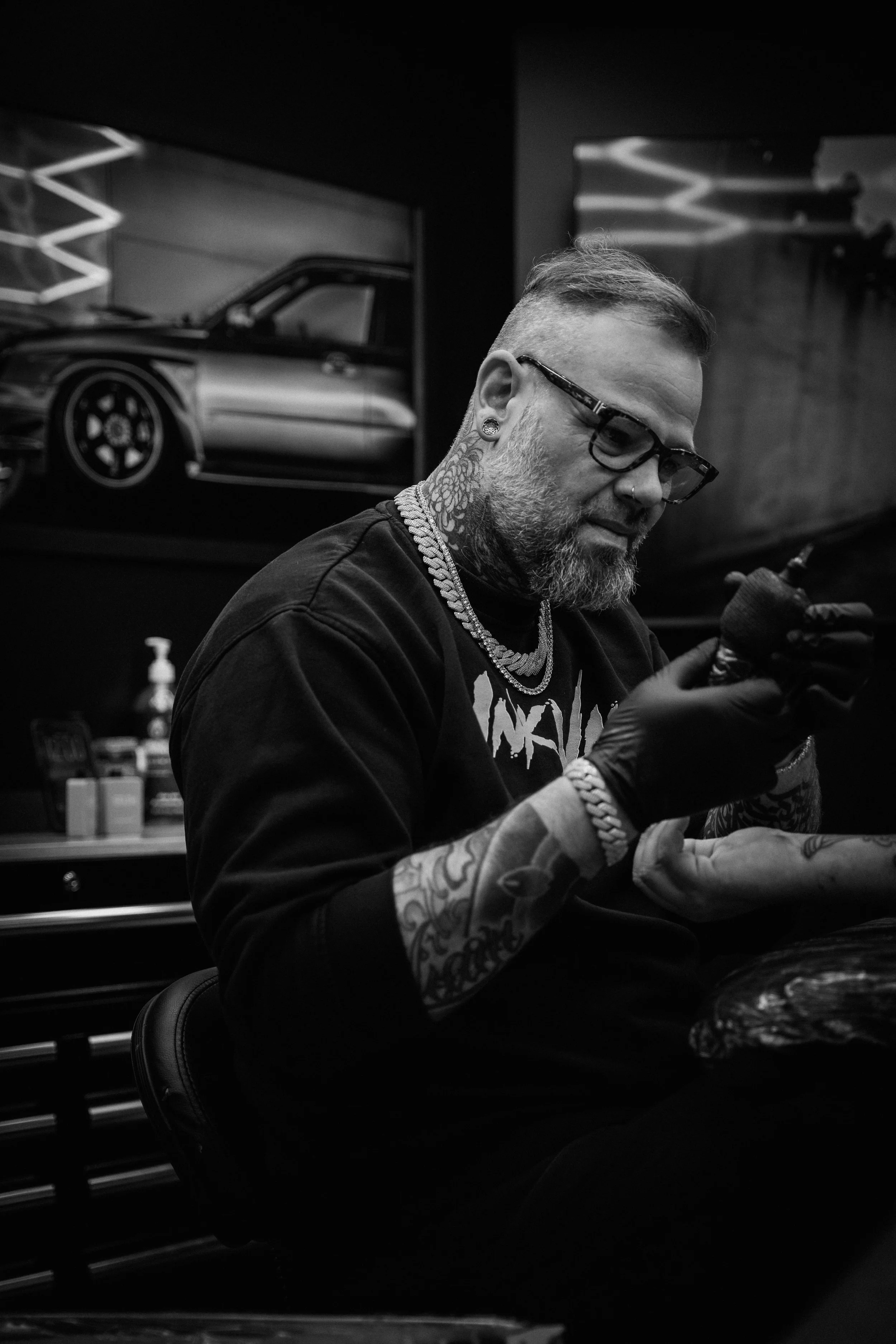 Hugo tatouant le bras d’un client dans le studio privé InkVault à Mirabel.