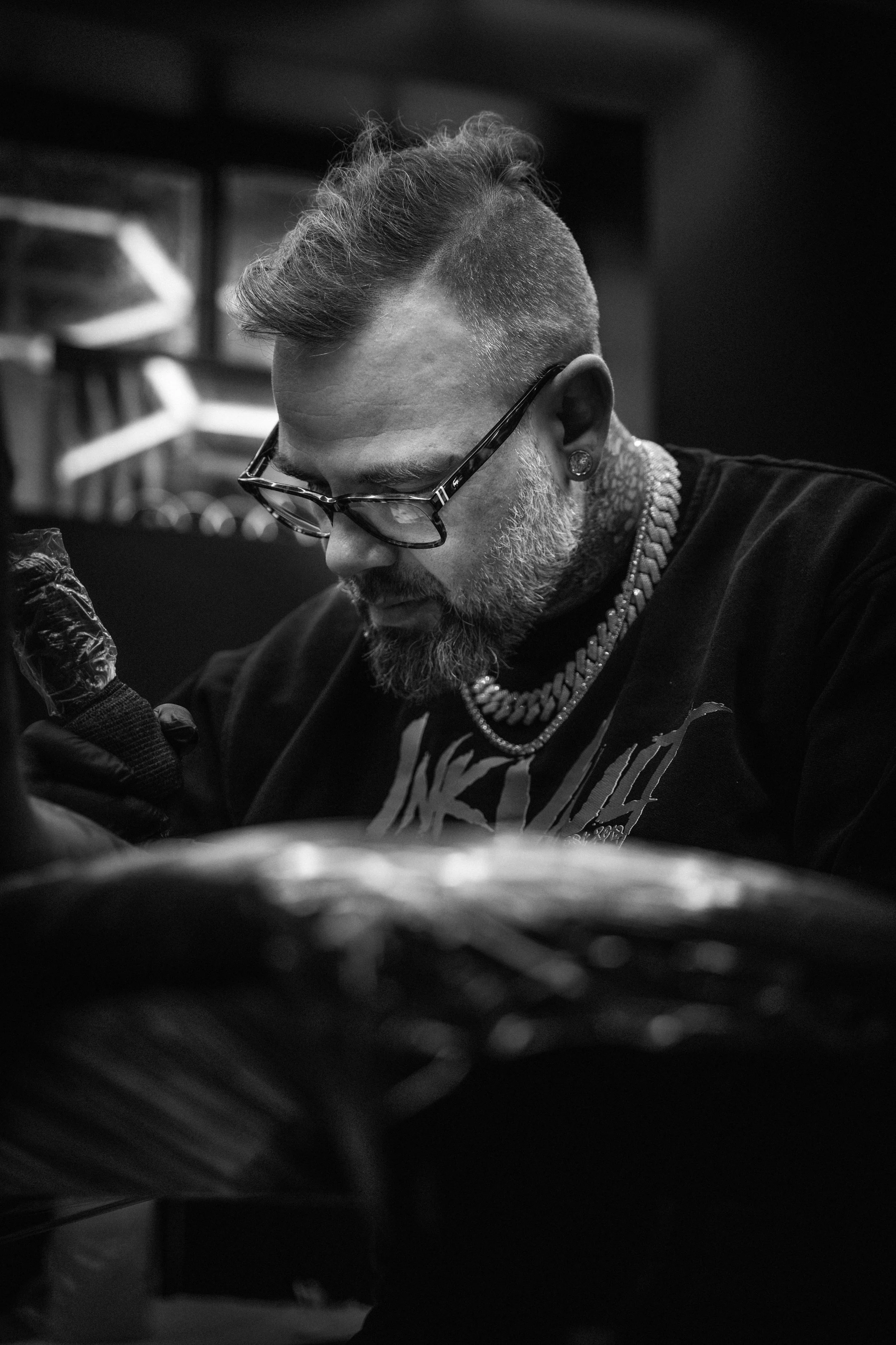 Hugo concentré pendant une séance de tatouage au studio InkVault à Mirabel.