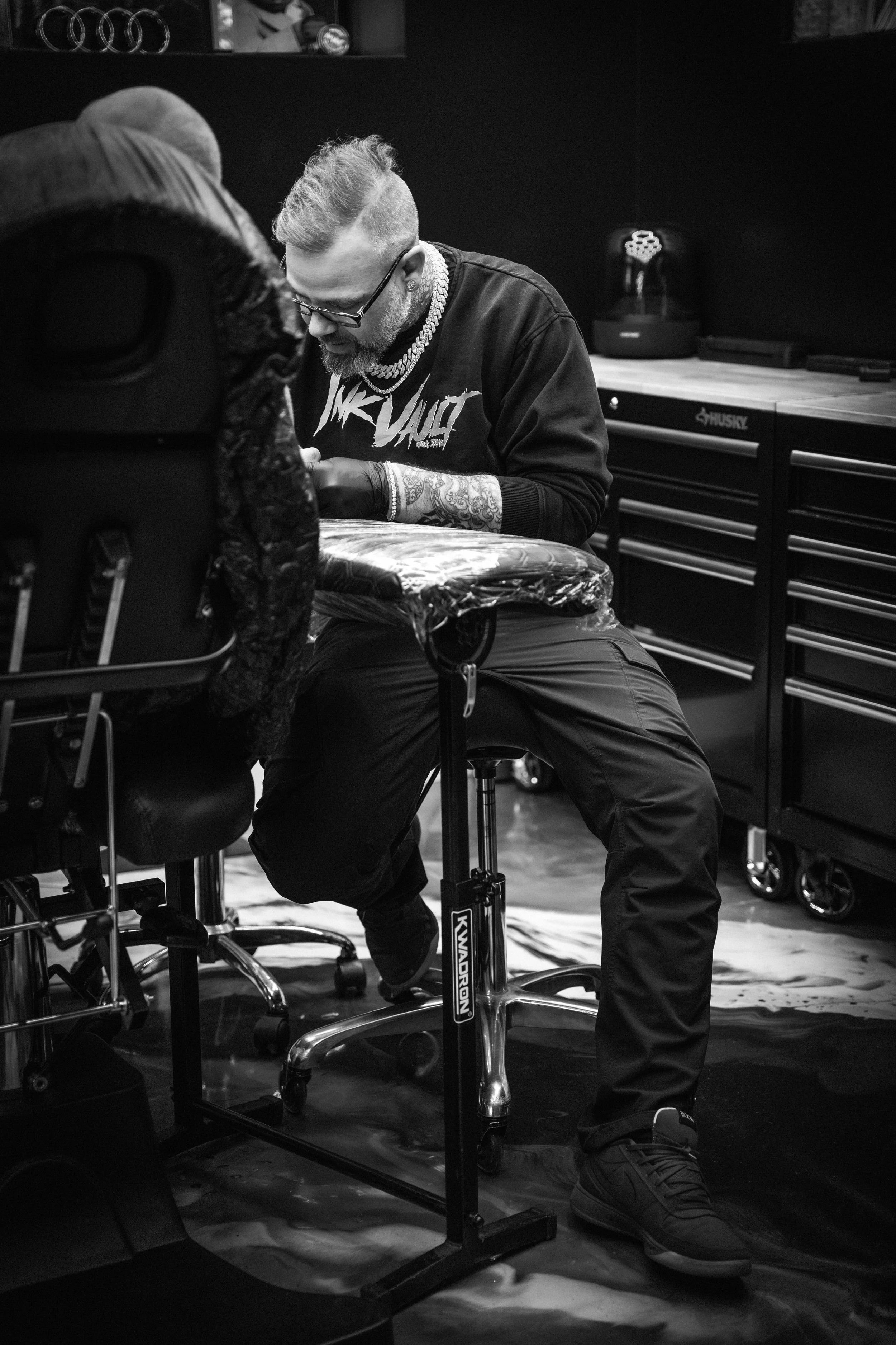 Hugo tatouant le bras d’un client dans le studio privé InkVault à Mirabel.