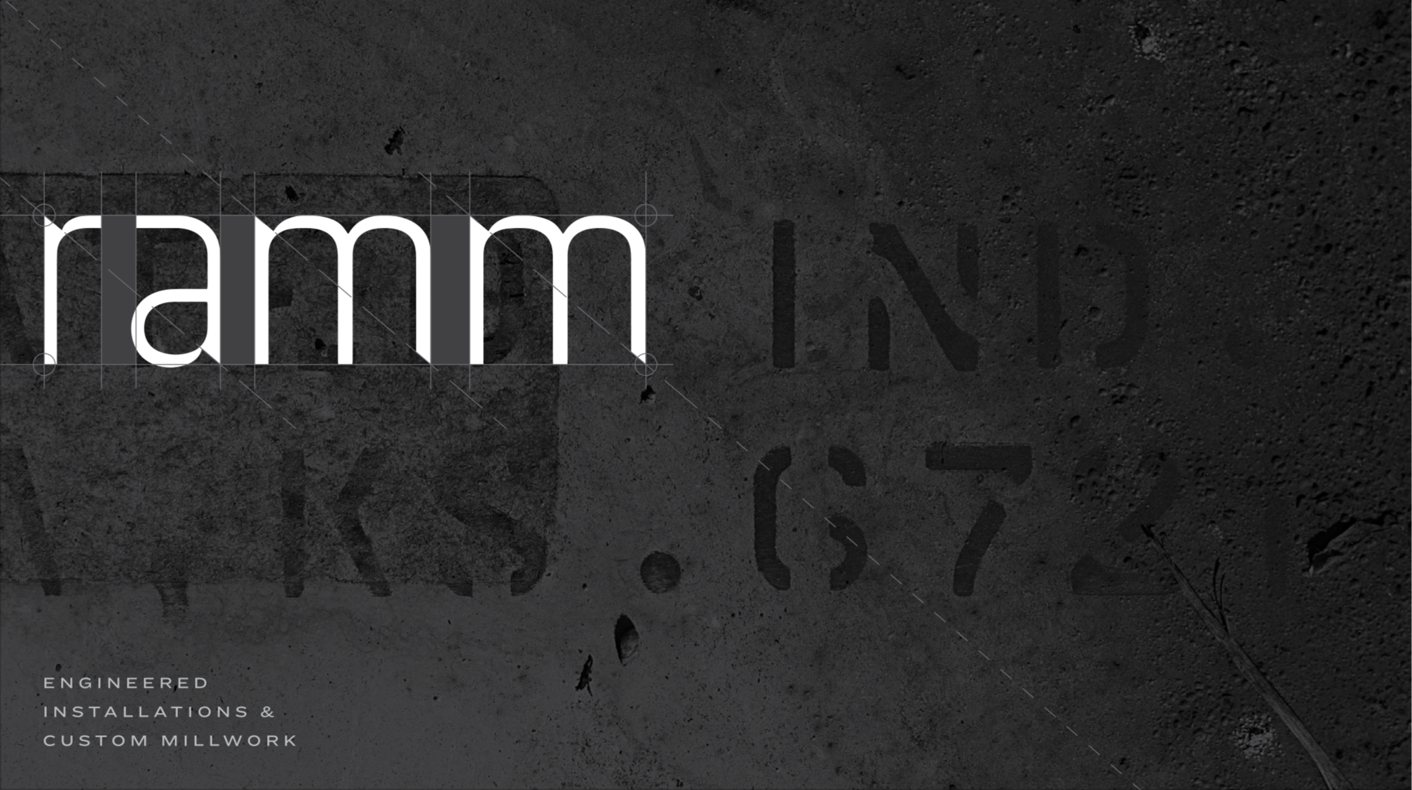 Close-up of a dark textured surface with the partially visible text 'INSTALLED' and the phrase 'ENGINEERED INSTALLATIONS & CUSTOM MILLWORK' at the bottom left corner. Overlaid is the word 'ram' in large white font.