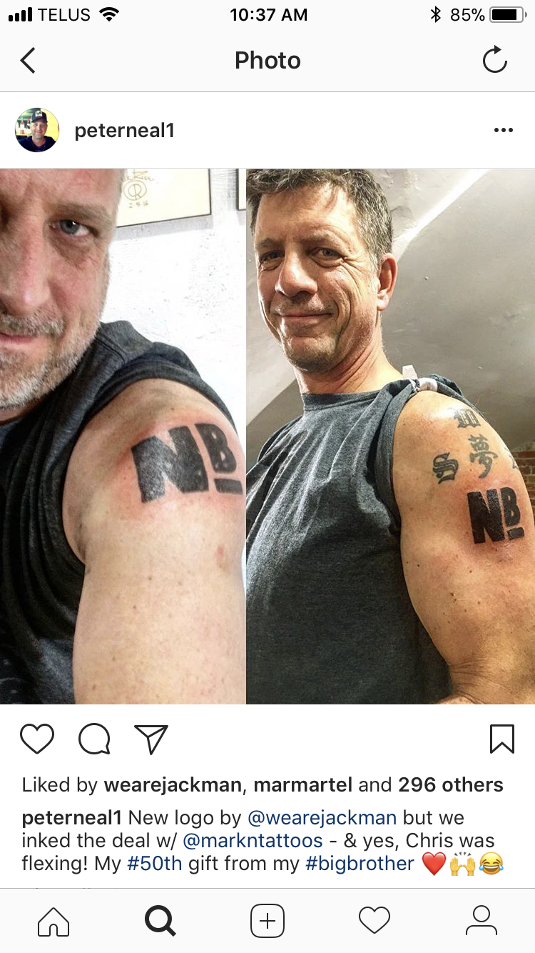 A side-by-side comparison of two men showing their tattooed upper arms. The man on the left has a tattoo that reads 'NB', and the man on the right has a similar tattoo but with additional text above it.
