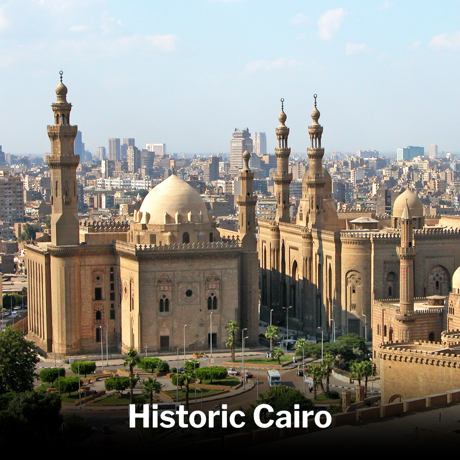 A view of a historic Islamic mosque with tall minarets and domes, overlooking a modern cityscape in Cairo, Egypt, with the text 'Historic Cairo' at the bottom.