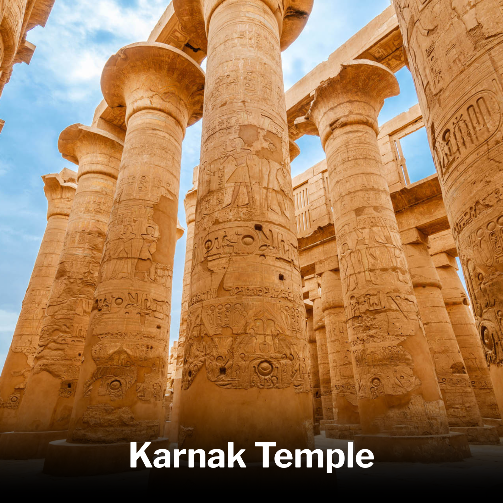 Ancient Egyptian temple with tall sandstone columns inscribed with hieroglyphics, labeled as Karnak Temple under a blue sky.