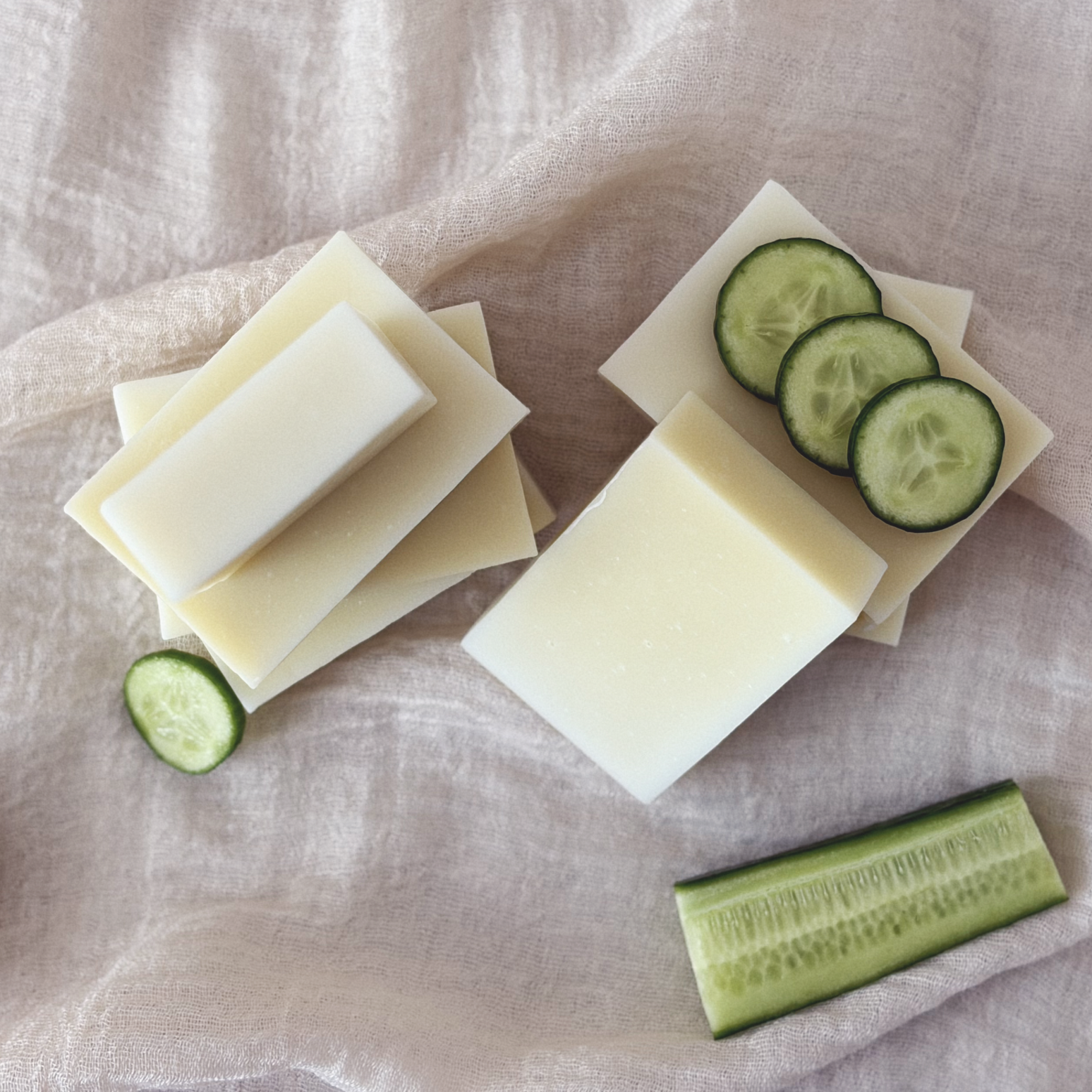 Slices of cucumber, pieces of white cheese, and a piece of cucumber on a soft cloth background.