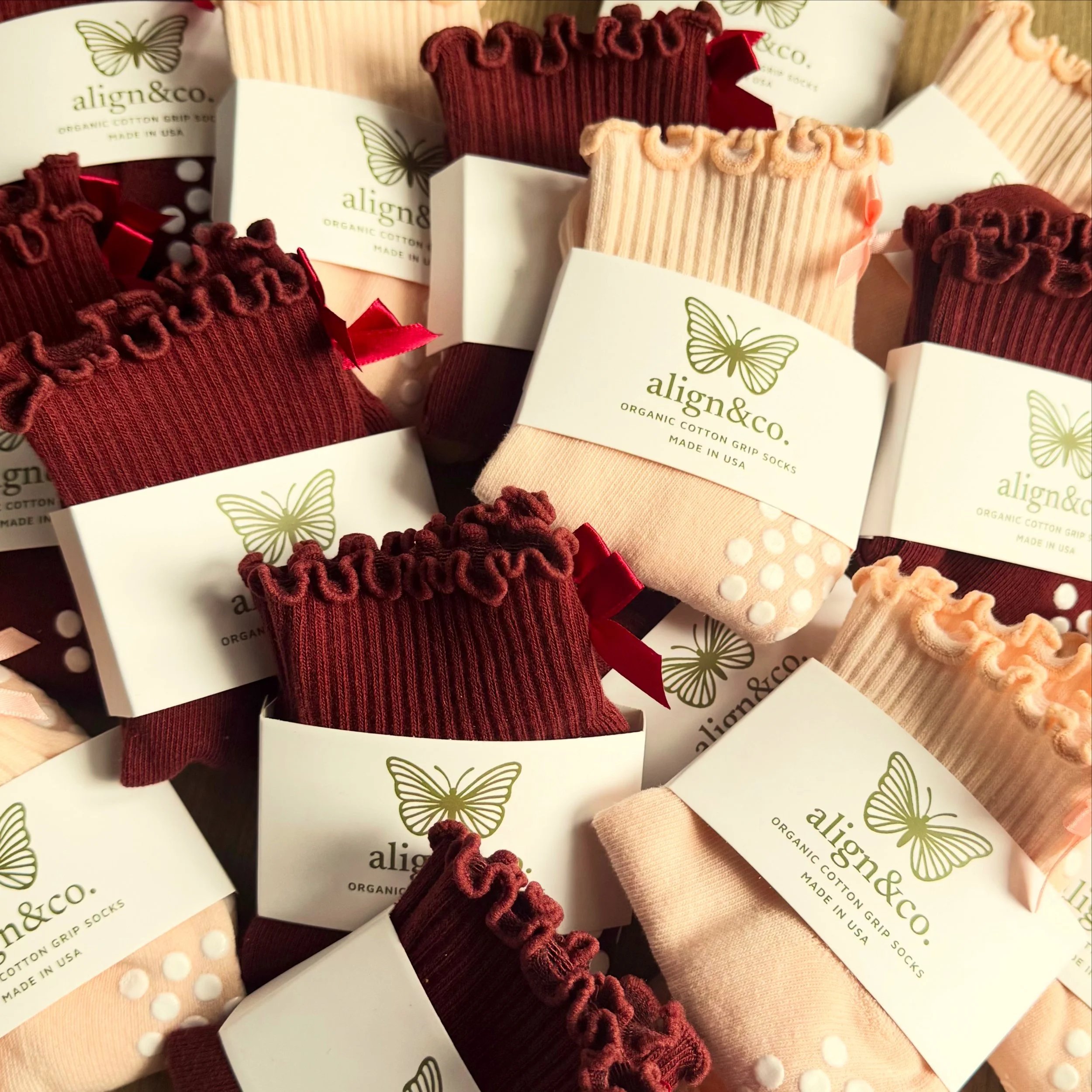 align&co. organic cotton Pilates grip socks in burgundy, tan, and light pink, thoughtfully designed for Pilates, barre, and everyday movement.
