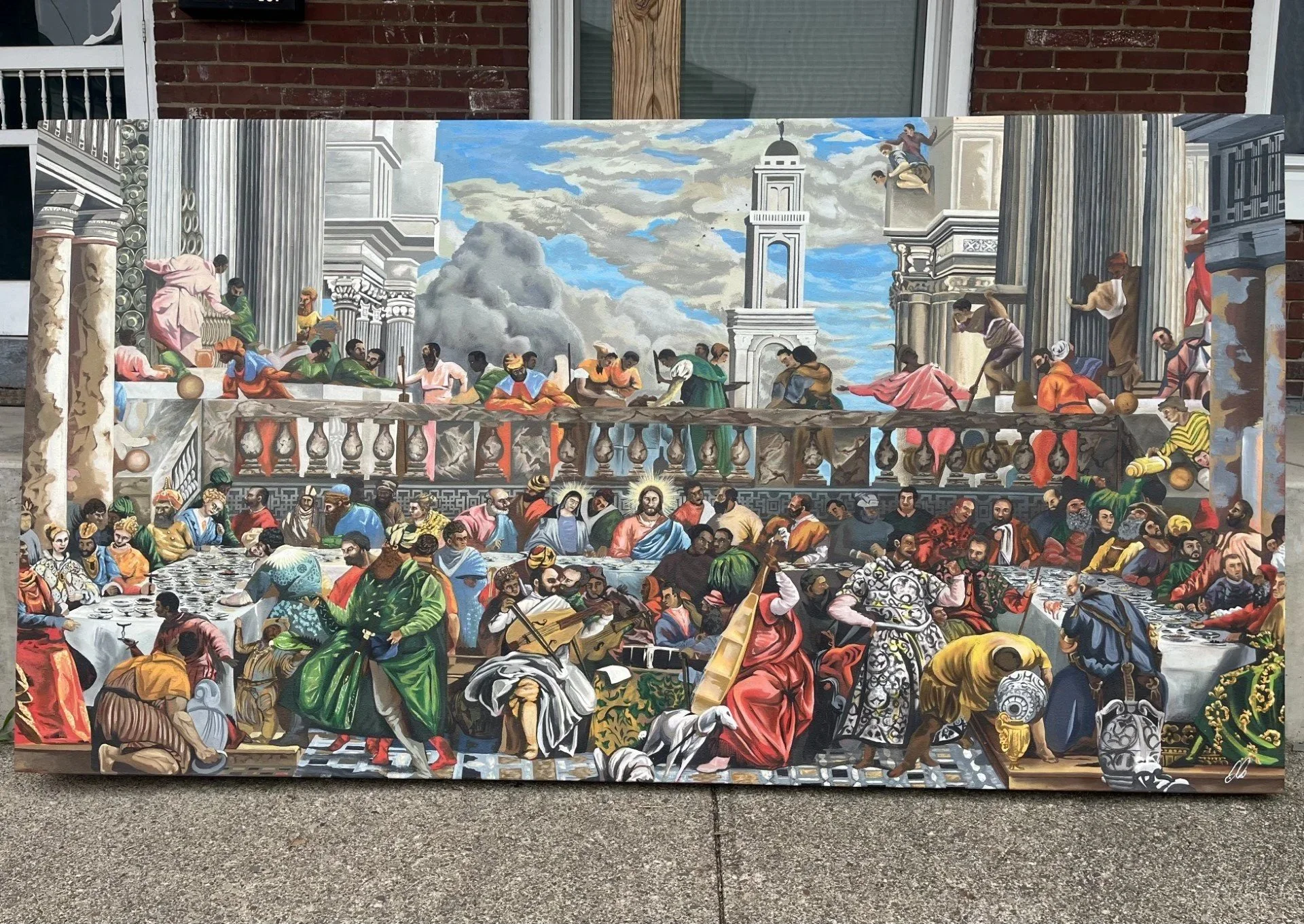 A detailed mural depicting a biblical scene with numerous people gathered for what appears to be a communal meal, set against the backdrop of classical columns, a building, and a cloudy sky.