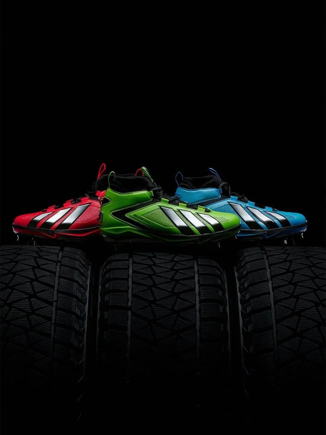 Three pairs of colorful running shoes in red, green, and blue, displayed on tires with a black background.