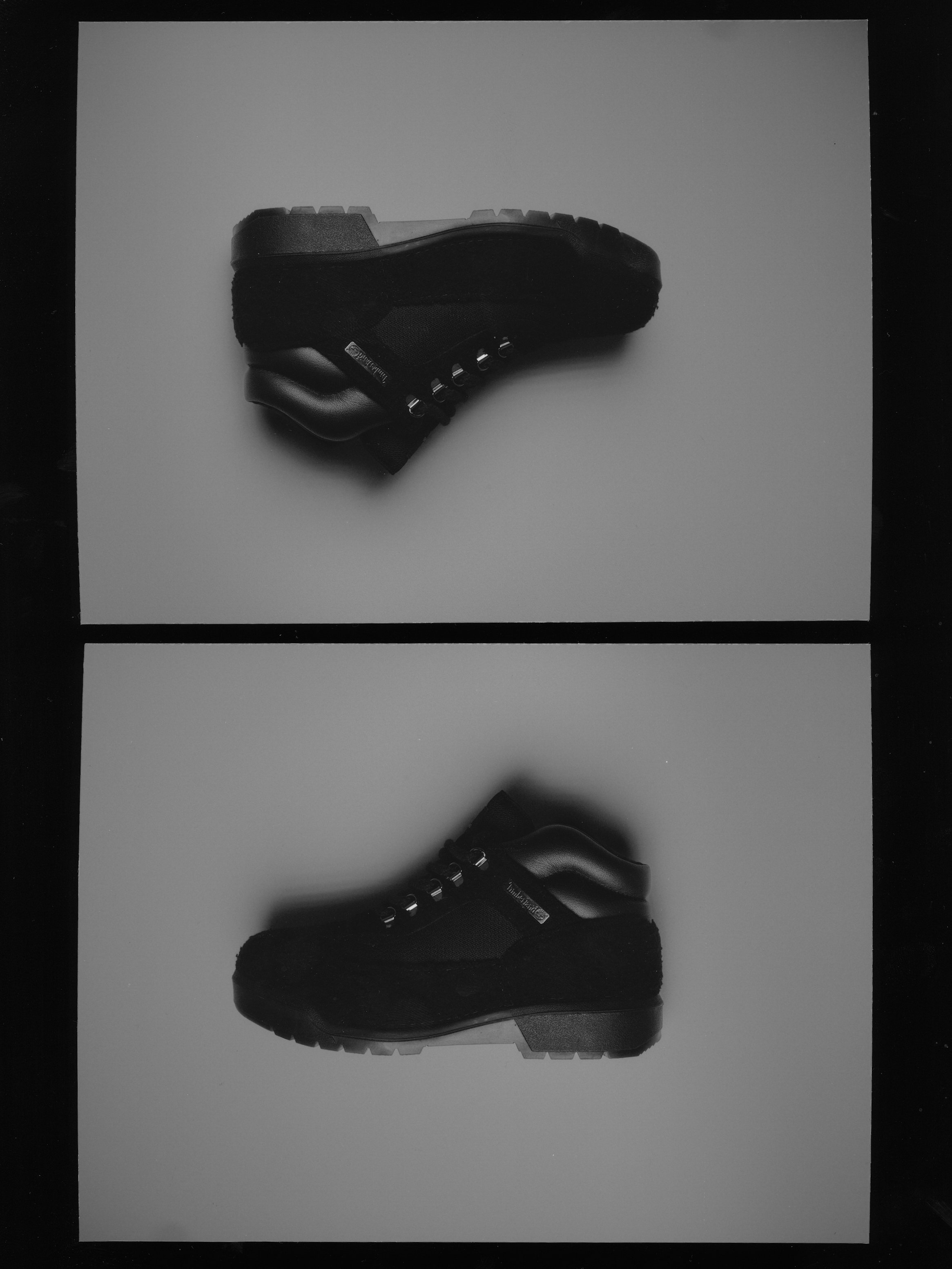Black boots on white paper with a black background.