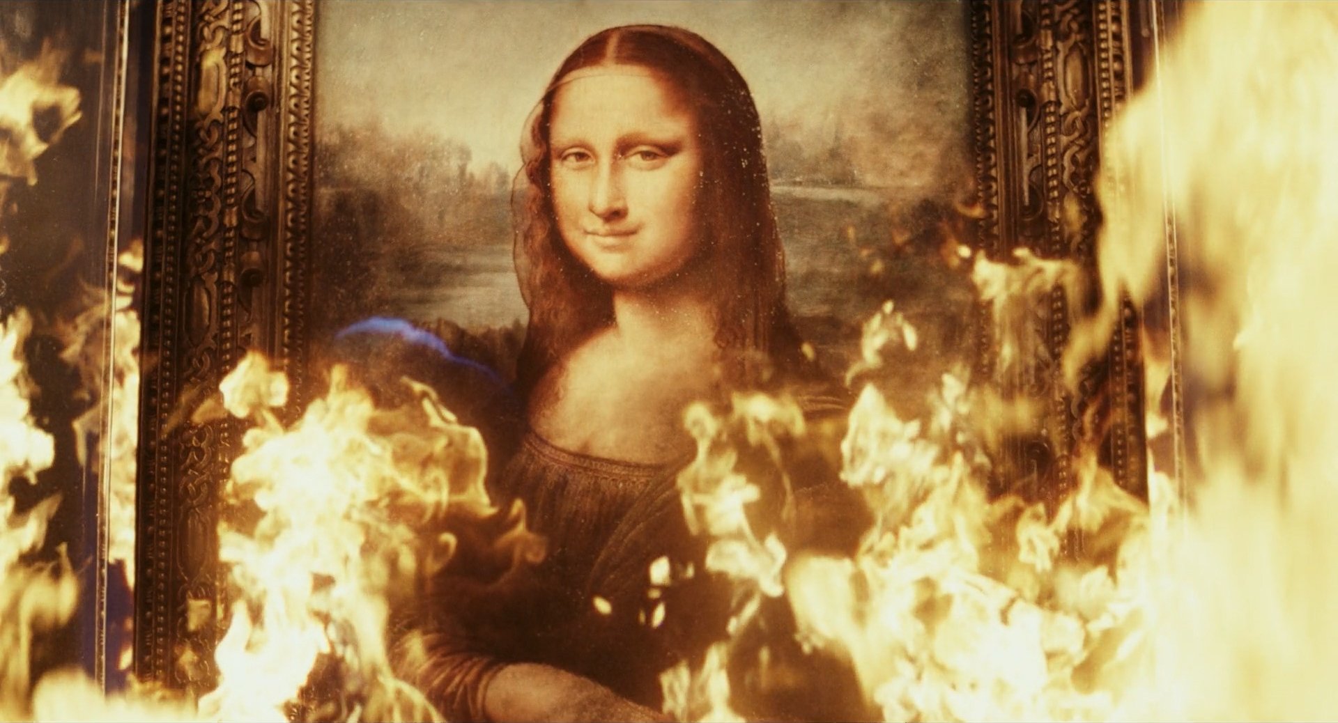 Still from Glass Onion. Burning picture of Mona Lisa. The image shows the famous portrait with flames surrounding it.