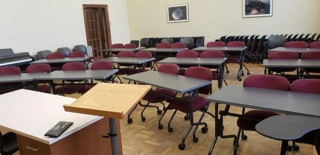 EM108 at Vic: empty classroom with tables and chairs, a whiteboard, and space-themed artwork on the walls.