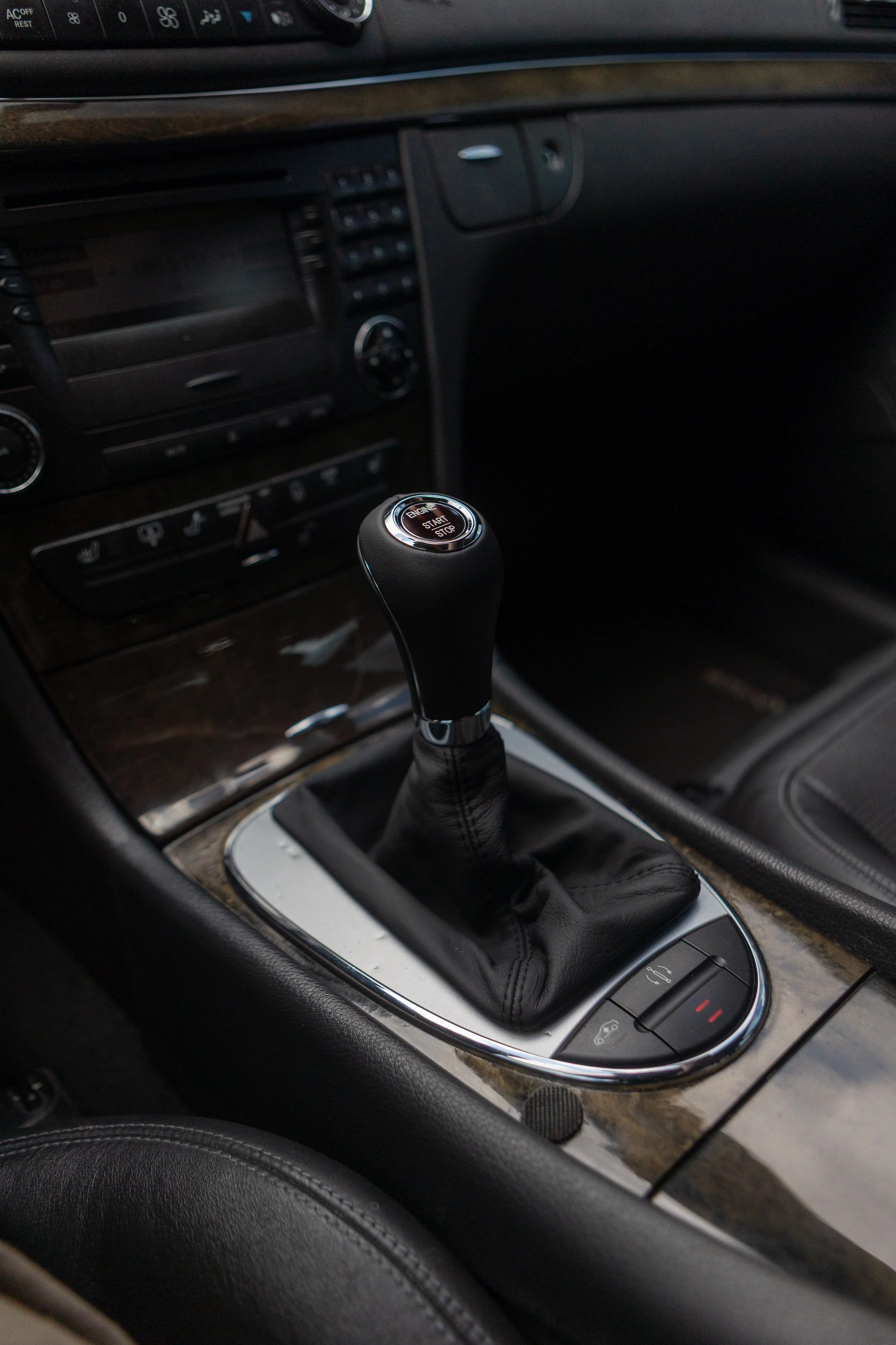 The interior of a car showing the gear shift, dashboard, and control panel with a woodgrain finish.