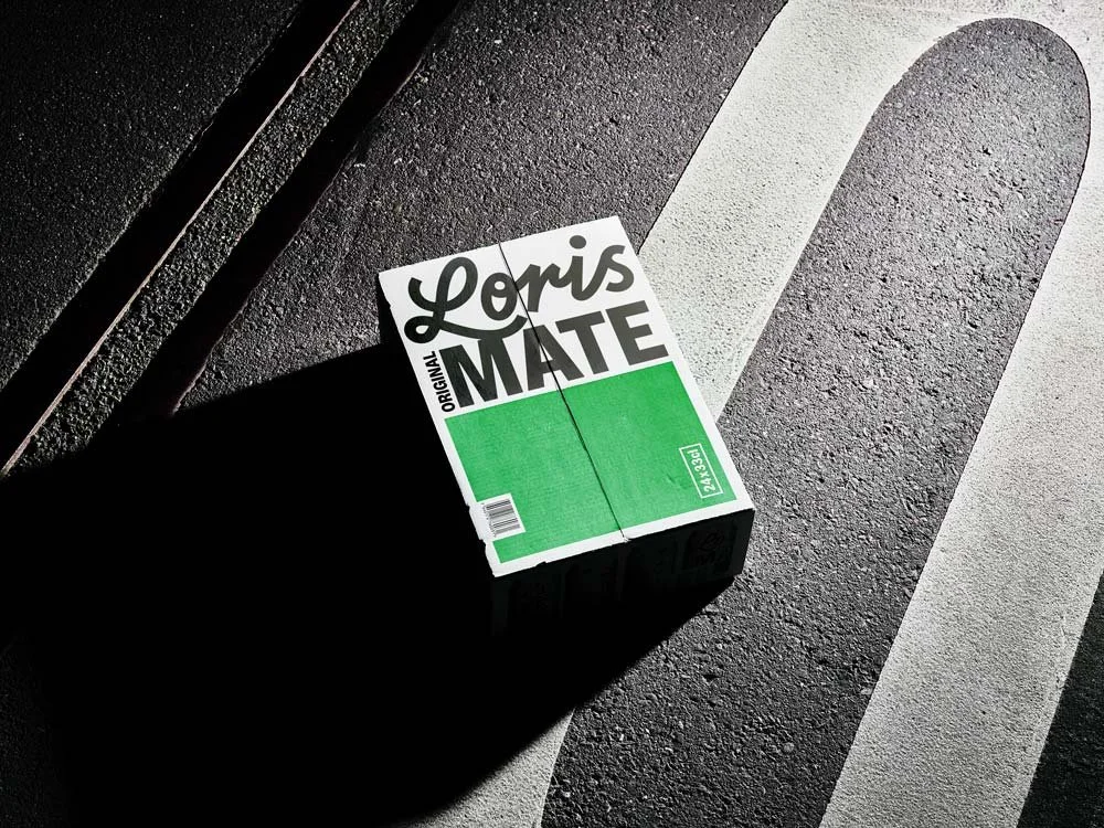 Eine Packung mit Zigaretten auf das Asphalt, Sonnenlicht wirft einen Schatten.