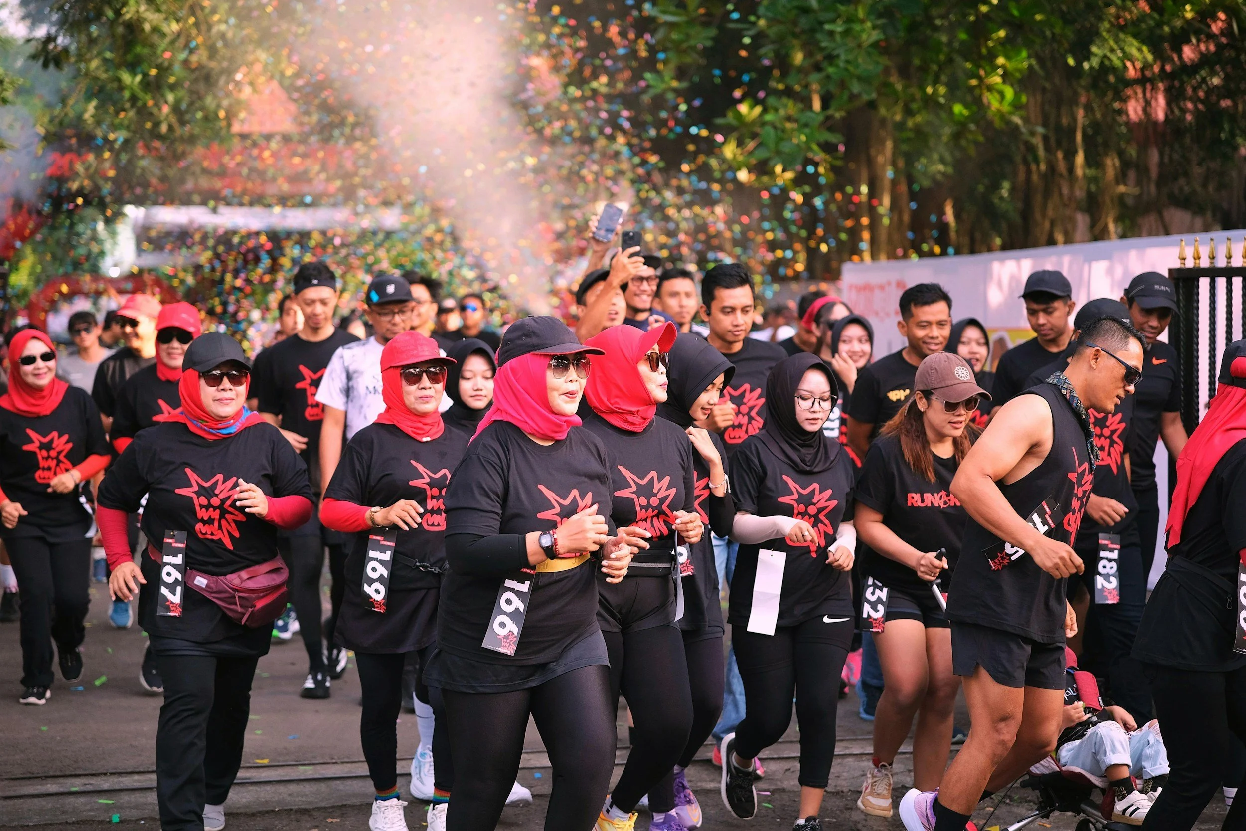 Run Collective UK corporate team running through confetti at a branded team event