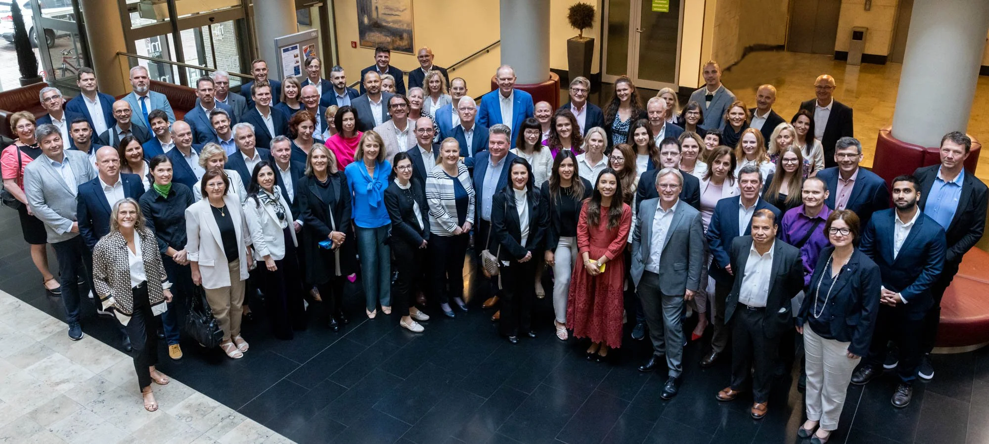 Group of business people posing together in a lobby.