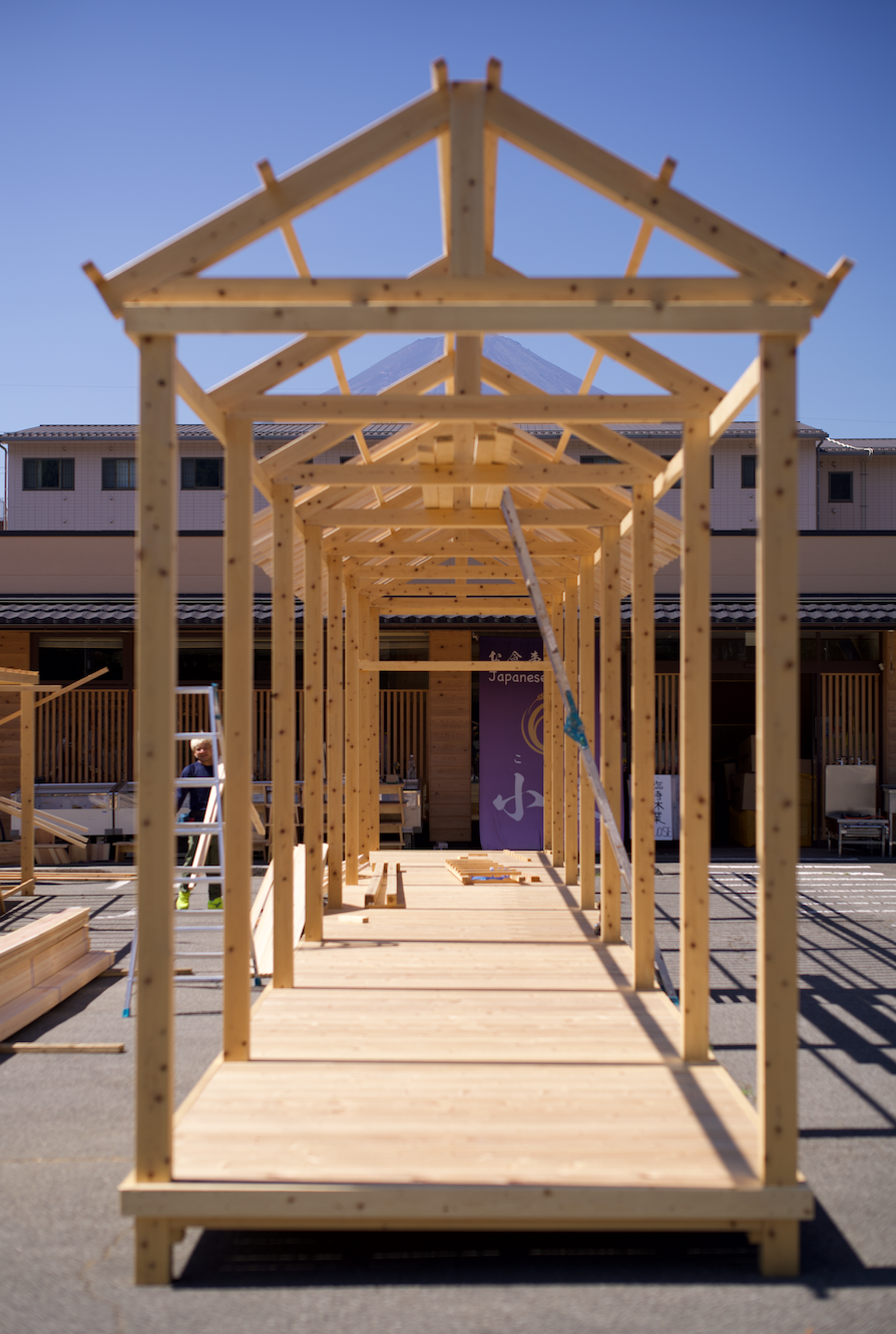 Wooden framework of a small building under construction outdoors.