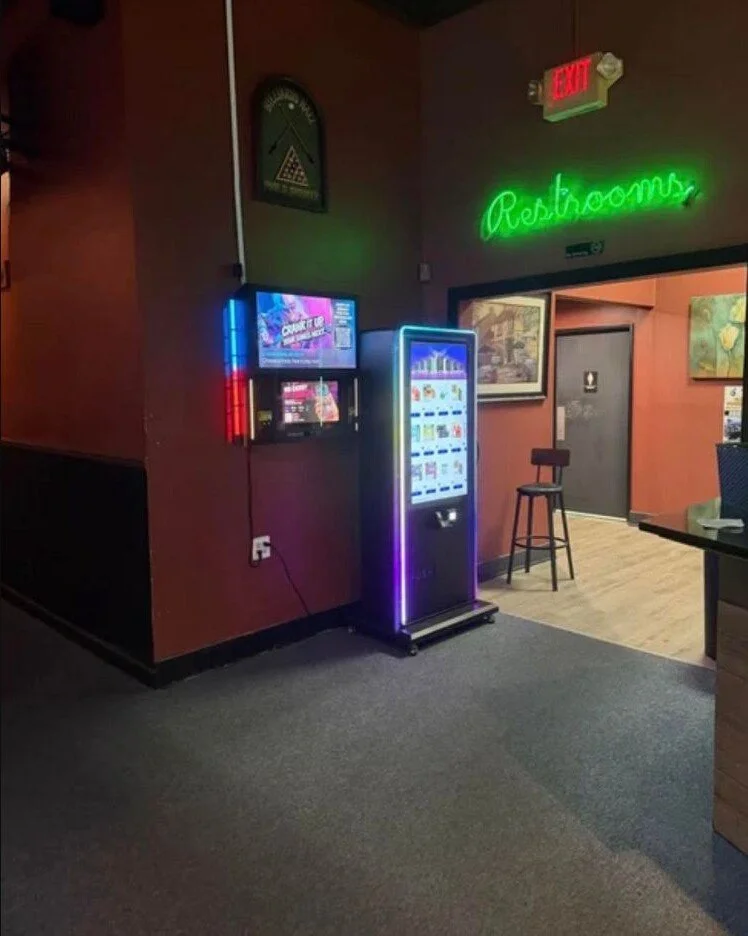 Modern wall-mounted vending machine installed in a nightlife venue.
