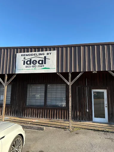 Exterior of a building with a sign that reads 'Remodeling by Ideal' and a phone number, under a clear blue sky.
