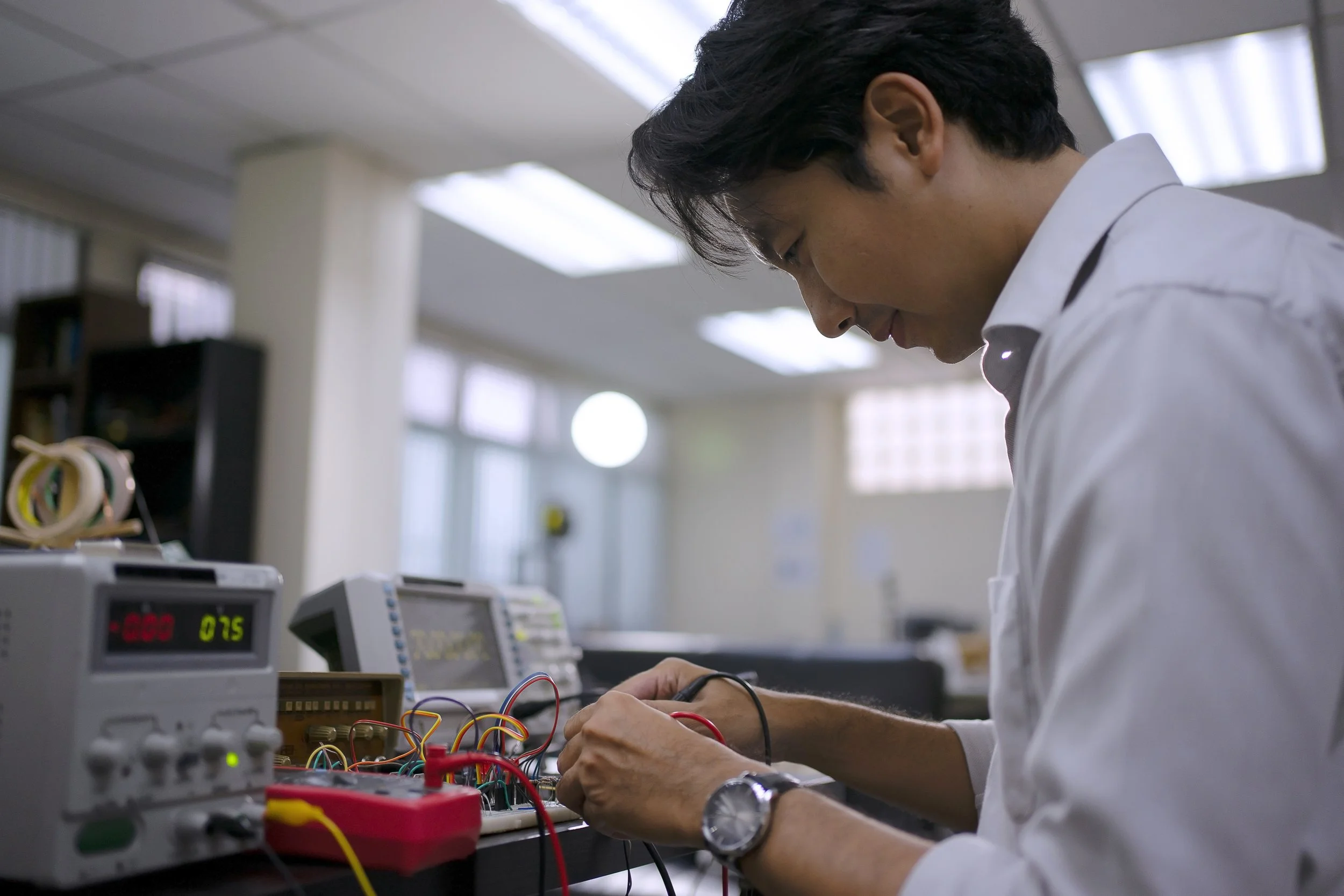 Un chercheur examine un circuit électronique dans un laboratoire.