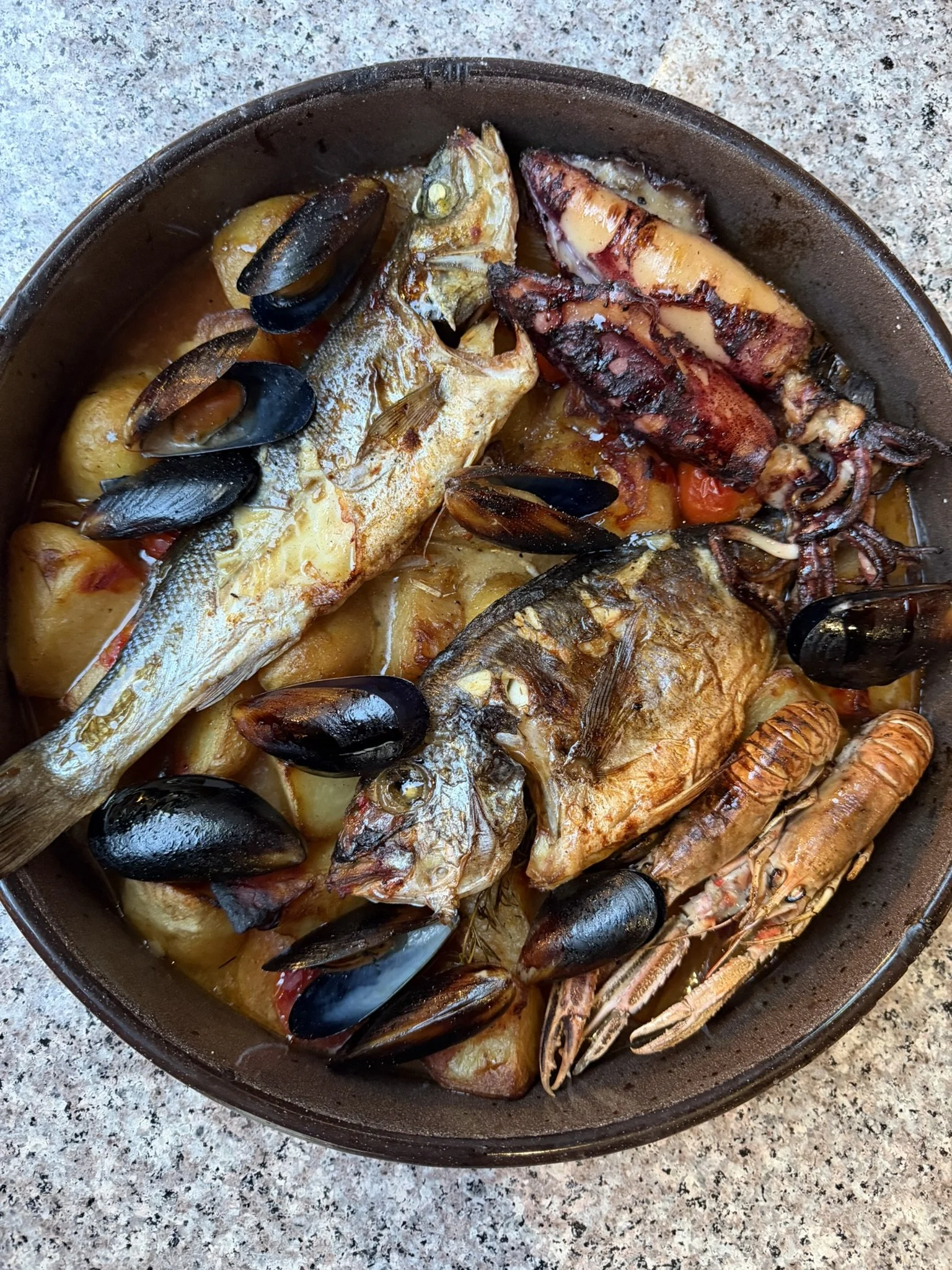 A seafood dish with grilled fish, octopus, shrimp, mussels, and potatoes in a skillet on a granite countertop.
traditional Dalmatian peka, slow-cooked meat Croatia, local food Skradin, authentic dining experience, restaurants in Skradin town