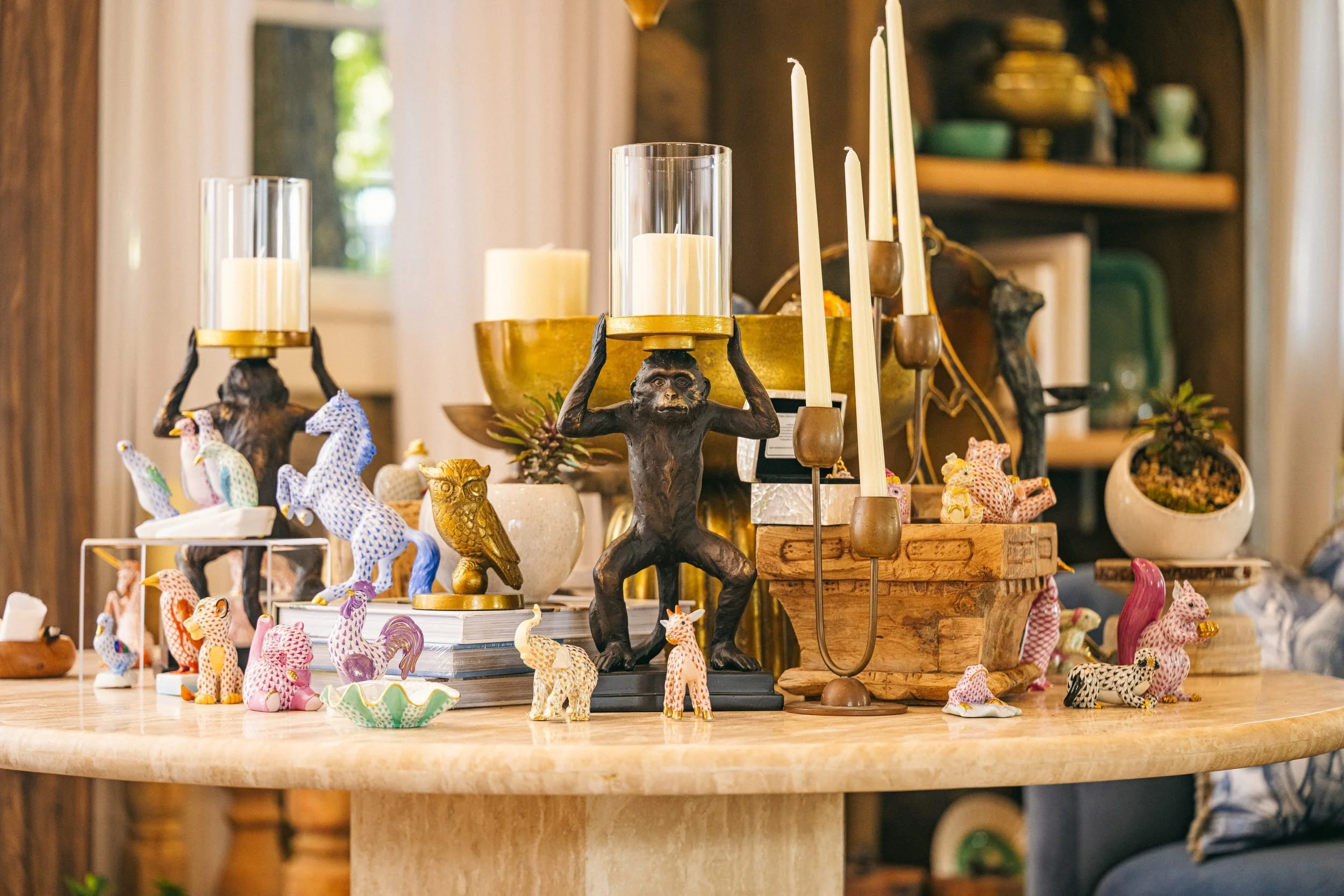 Candlelight, brass and collected porcelain on the travertine table.