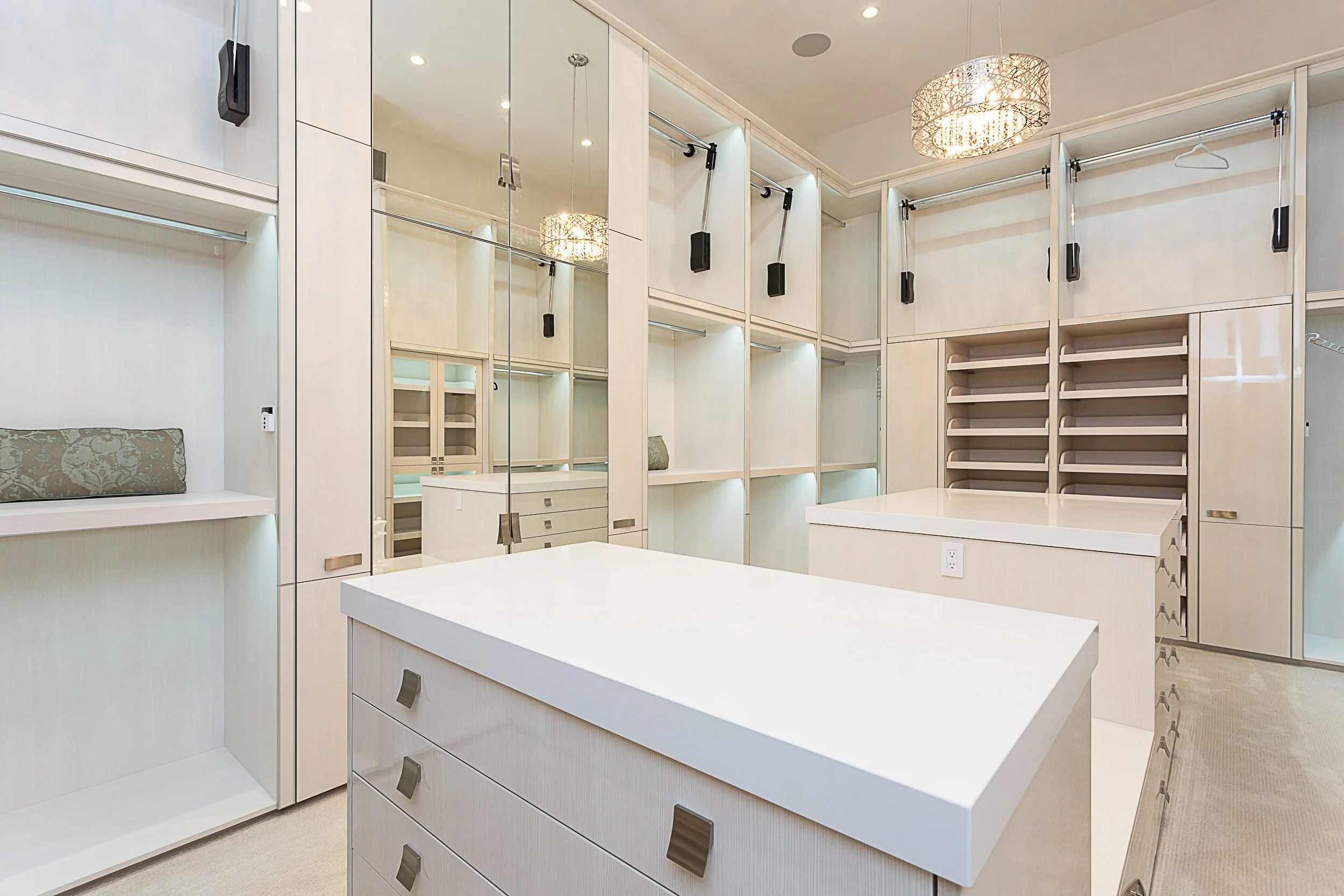 A white dressing room with a central island and built-in shelving.