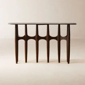 A wooden console table with curved legs and a flat rectangular top, set against a plain wall.