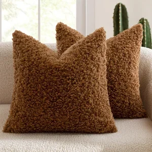 Three brown, plush decorative pillows on a sofa with cacti in the background.